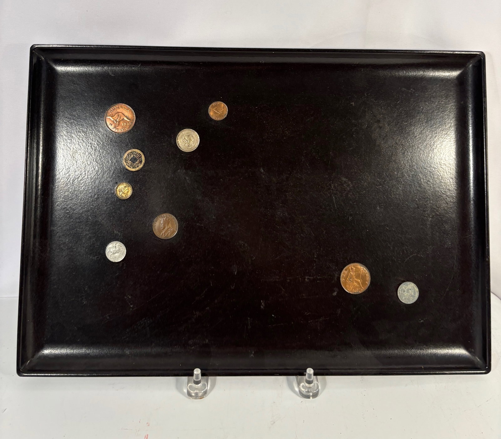 Asian Black Lacquer Tray with Assorted World Coins: Asian black lacquer tray decorated with a landscape scene featuring figures, birds, trees, and water motifs. Accompanied by an assortment of world coins including an Australia 1945 penny, a Chinese sq