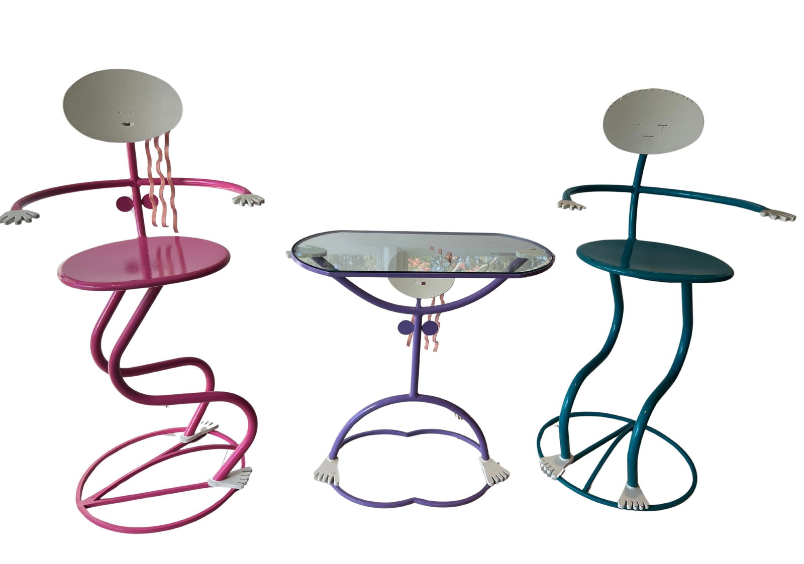 A Three-Piece Postmodern Memphis Style Anthropomorphic Furniture Set: A whimsical three-piece postmodern furniture set comprising two sculptural side chairs and a matching glass-top occasional table. Each piece is executed in brightly colored tubular metal with anthropo