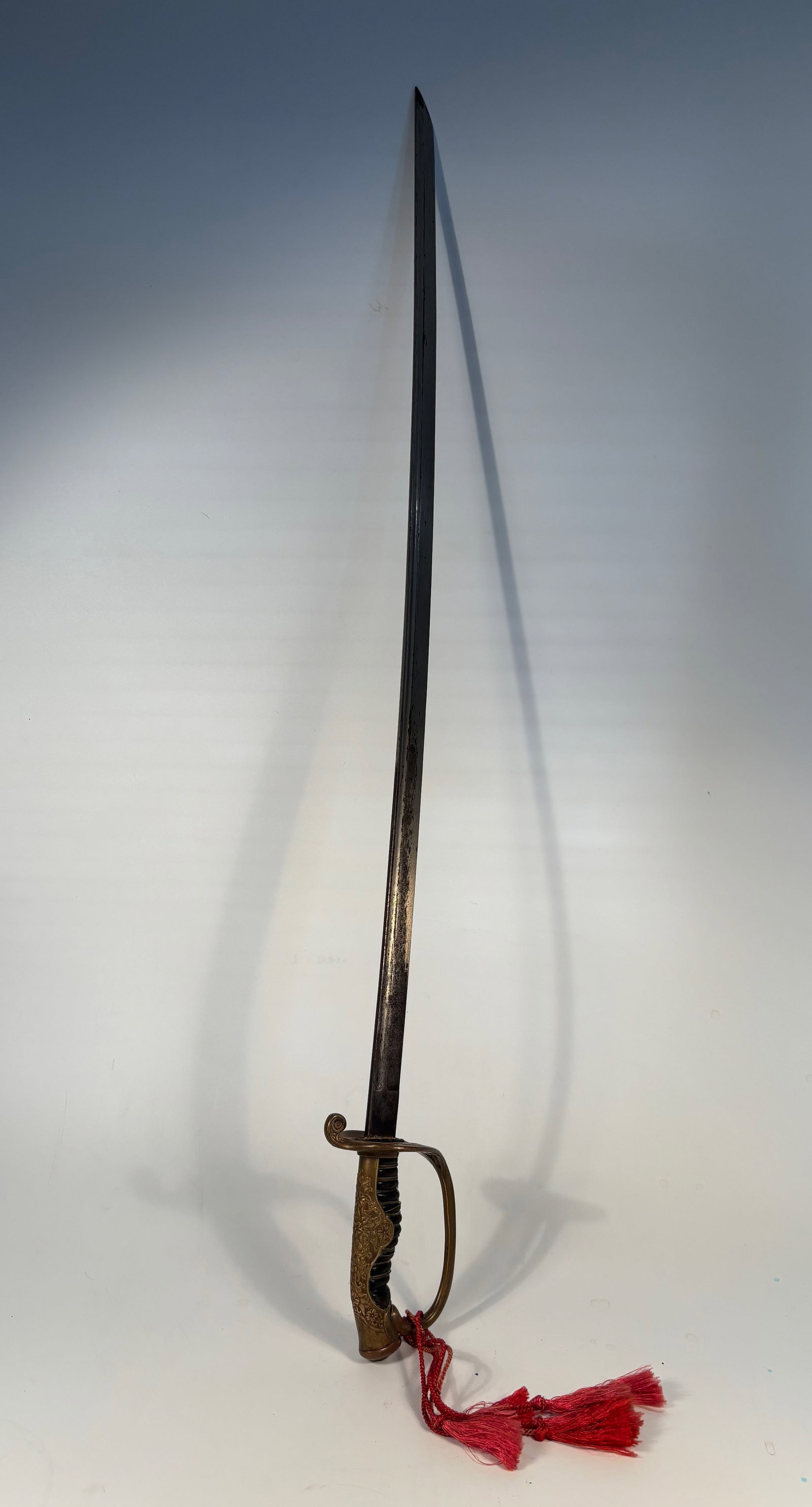 A Japanese WWII Police Sword: Very nice Japanese World War II era police sword with a beautiful hilt with profuse engraving on back strap. Scabbard in good condition with a couple depressions towards the drag. Blade it's nice and 