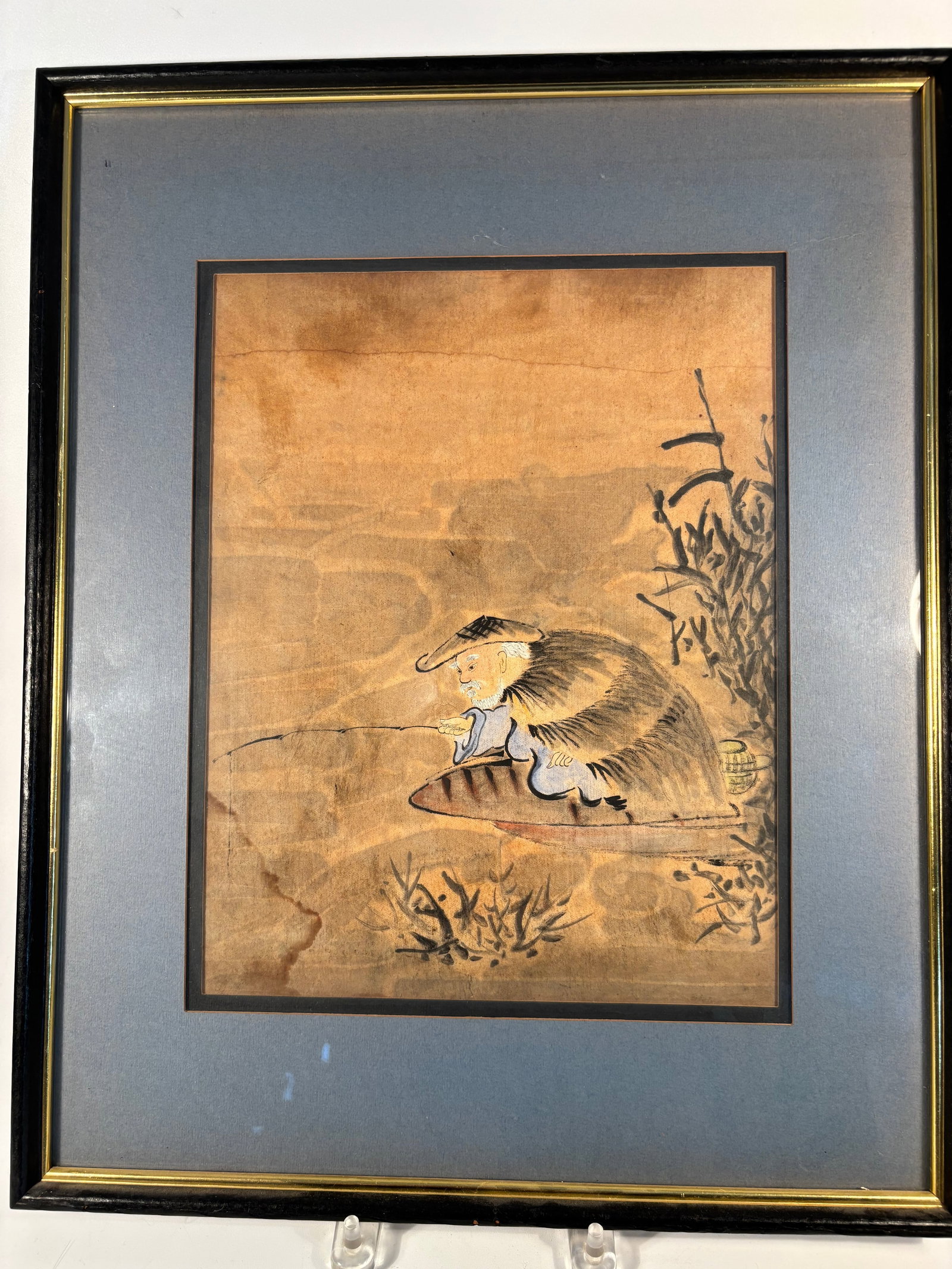 A Japanese Meiji Period Watercolor painting "Elderly Fisherman in Straw Cape with Fishing Rod": A delicate Japanese watercolor and ink painting on paper, likely dating to the Meiji period (1868–1912), depicting an elderly fisherman seated on a small wooden boat. The figure wears a traditional 