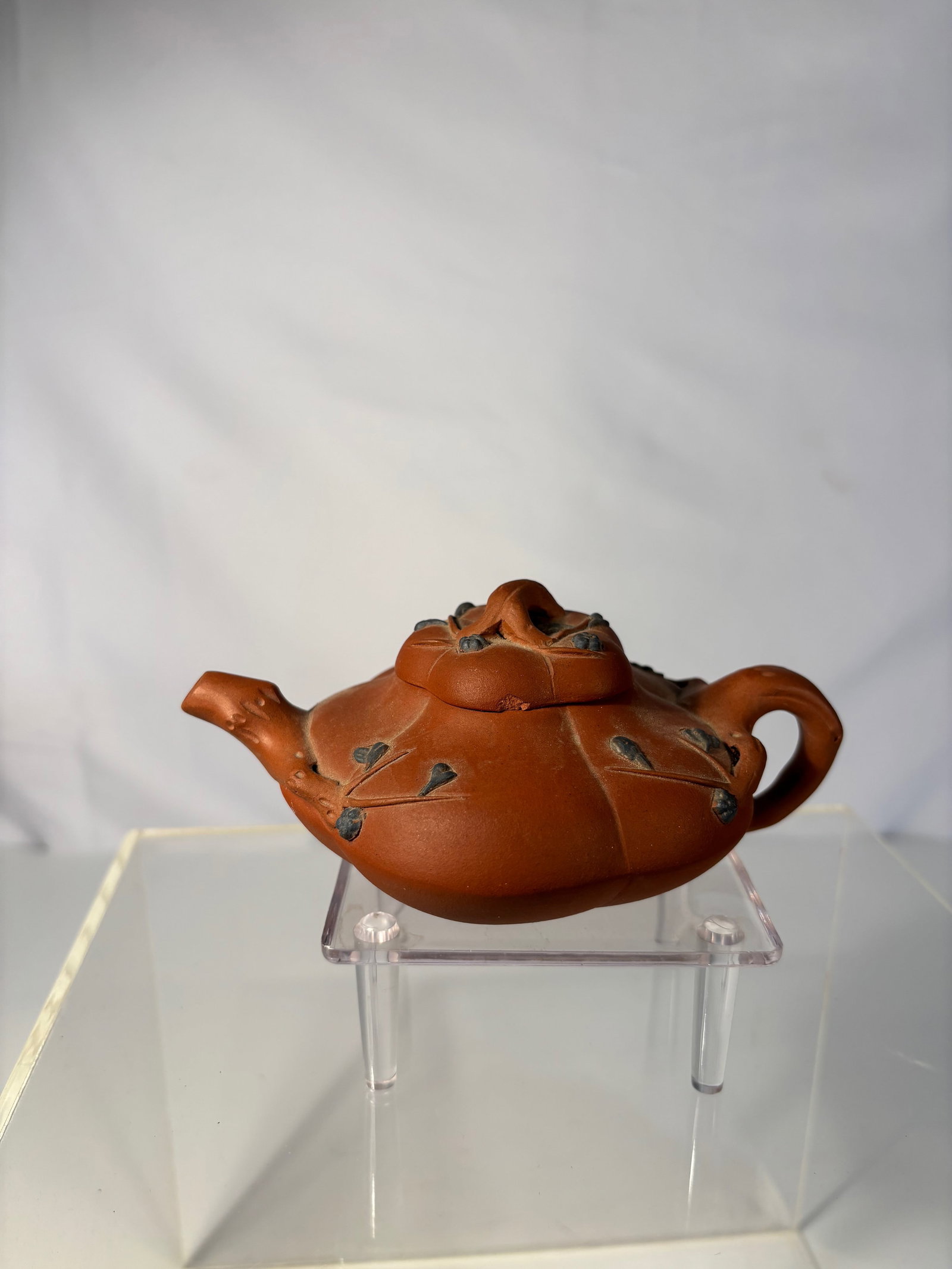 A Chinese Yixing Zisha Pumpkin-Form Teapot, Signed Zhu Yatong: 20TH Century ; A Chinese Yixing zisha (purple clay) teapot modeled as a pumpkin with applied vine and leaf decoration, the spout and handle formed as naturalistic branches. The base and interior of th