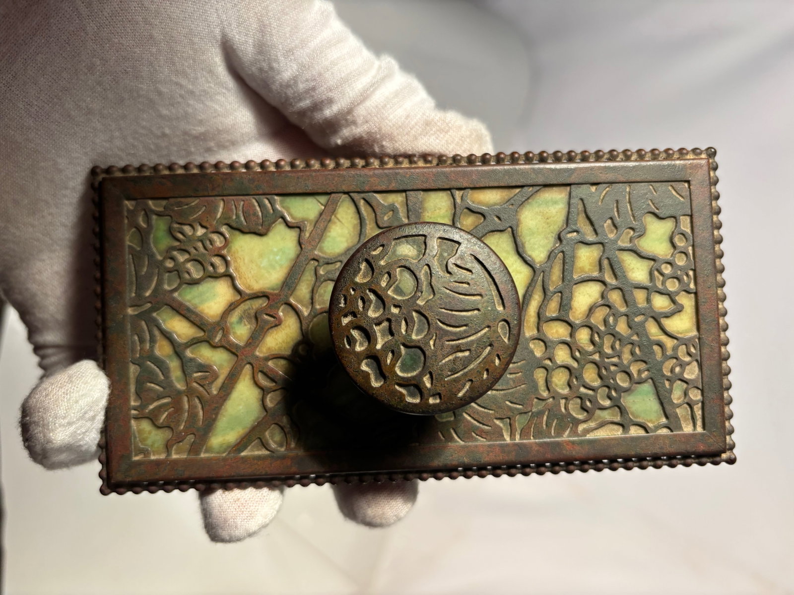 Tiffany Studios New York Grapevine Bronze Rocker Blotter Model 995: Early 20th century bronze rocker blotter by Tiffany Studios, New York. The piece is decorated with the classic grapevine motif in relief and retains its original knob handle. Marked to the underside �
