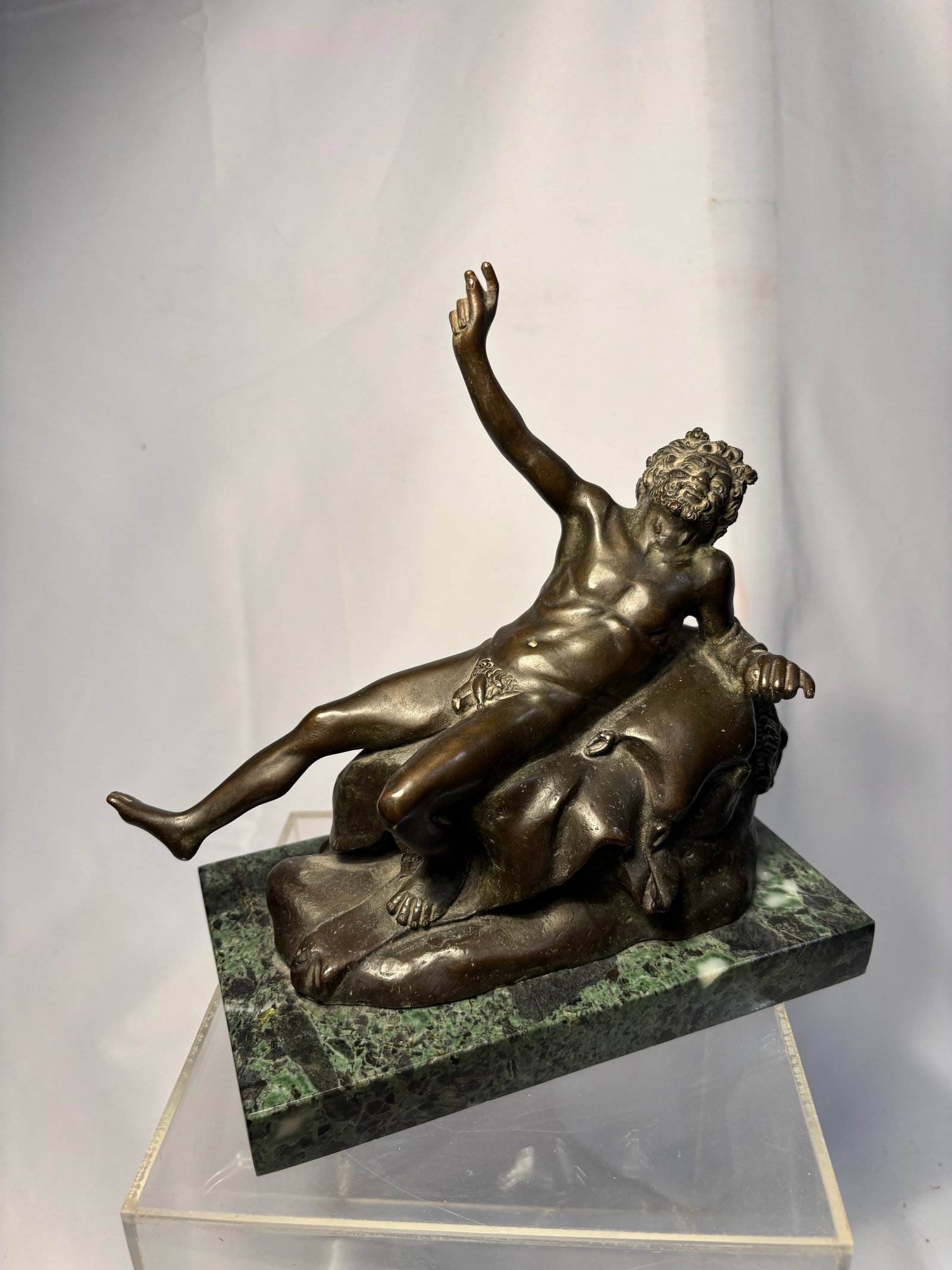 Neapolitan, 19th century, after the Antique Drunken Silenus on a rock: A patinated bronze sculpture depicting the mythological figure Silenus reclining upon a rockwork base, modeled after the Antique in the Neapolitan taste. The figure shown nude in a languid pose with r