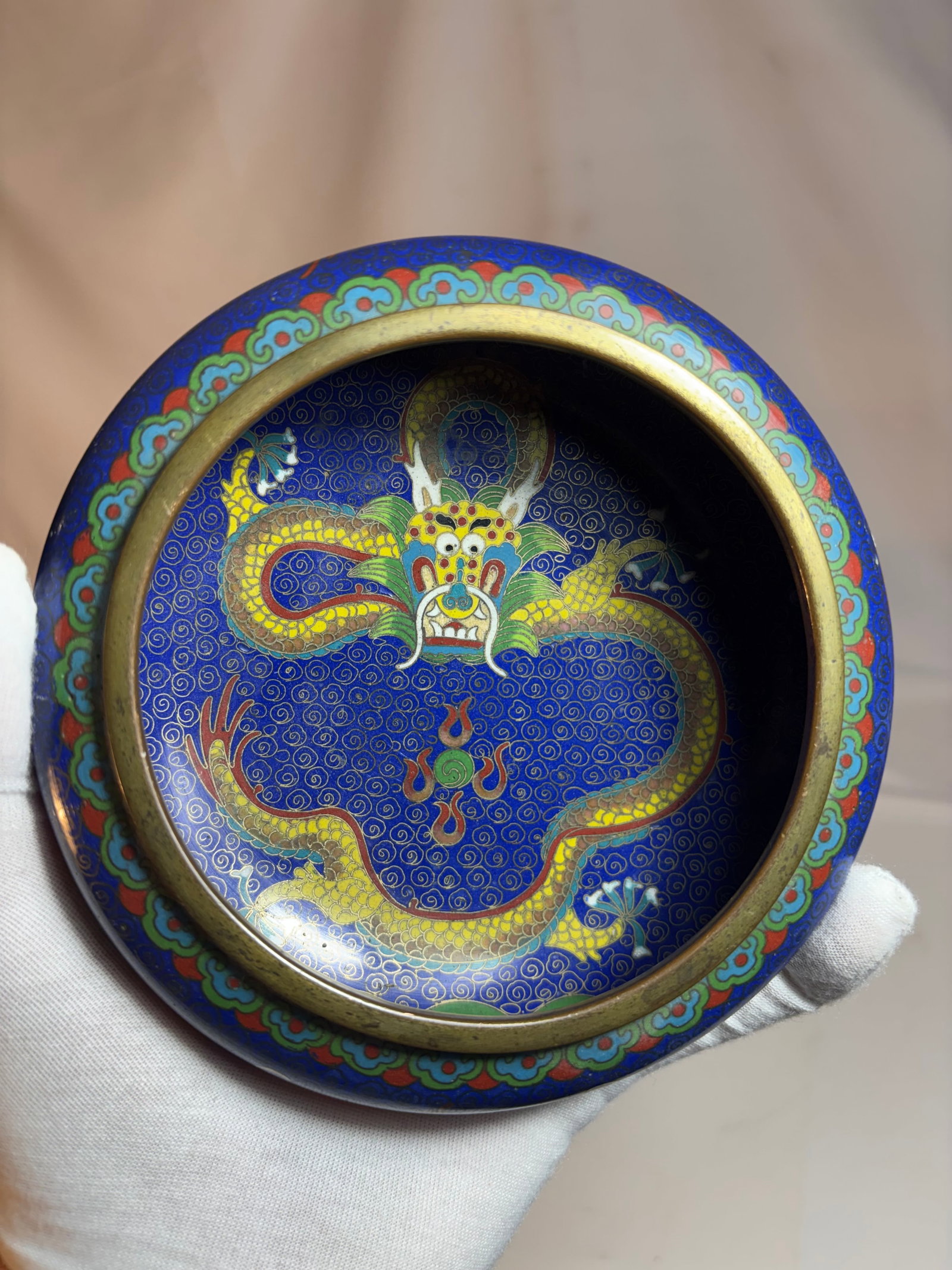 A Chinese Cloisonné Enamel Dragon Brush: Chinese cloisonné enamel brush washer or scholar’s brush dish, decorated with a coiled dragon amidst scrolling cloud motifs on a deep cobalt blue ground. The interior finished in turquoise enamel w