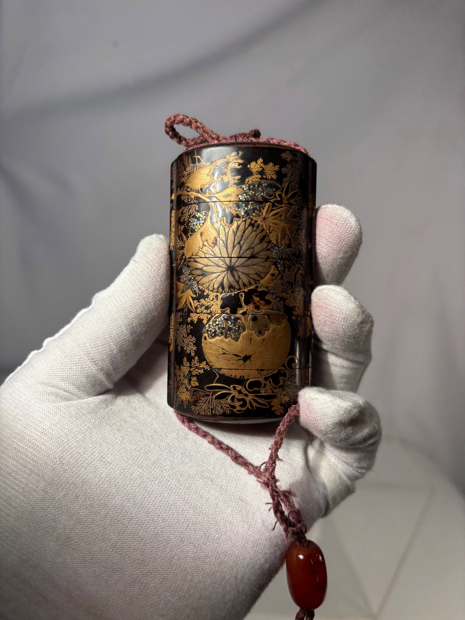 A Japanese Four-Case Black Lacquer Inr? with Gold Floral and Landscape Motifs, Likely late Edo to: circa 1800–1900, A Japanese black lacquer inr?, of cylindrical form, decorated in gold with finely detailed floral and landscape motifs, including stylized foliage and scenic elements rendered again