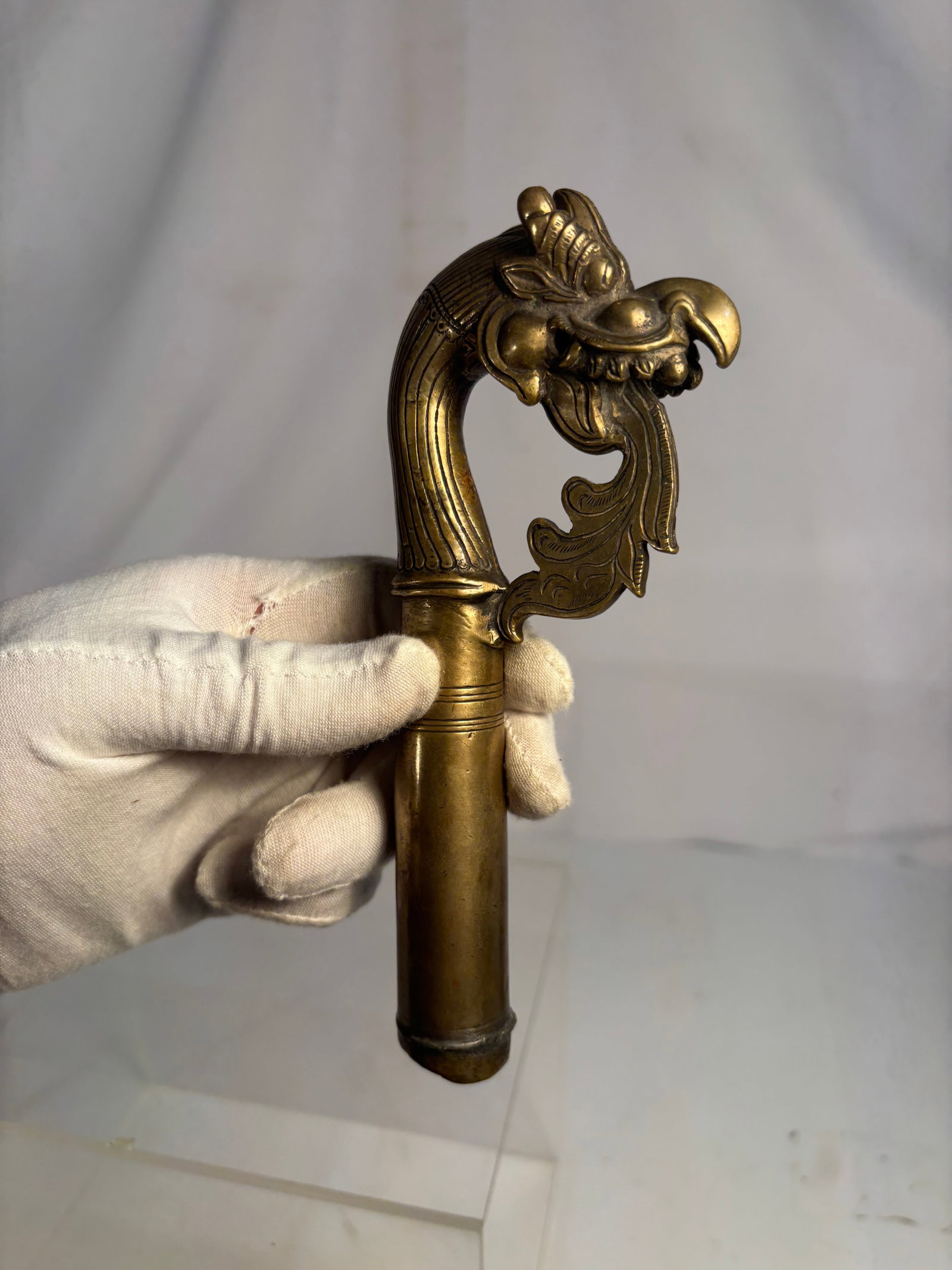 Antique Bronze Dragon Cane Handle: An antique cast-bronze cane or walking-stick handle, intricately modeled as a stylized dragon head with a curved neck, prominent eyes, scrolling mane and open mouth displaying teeth. Height: 7 inches