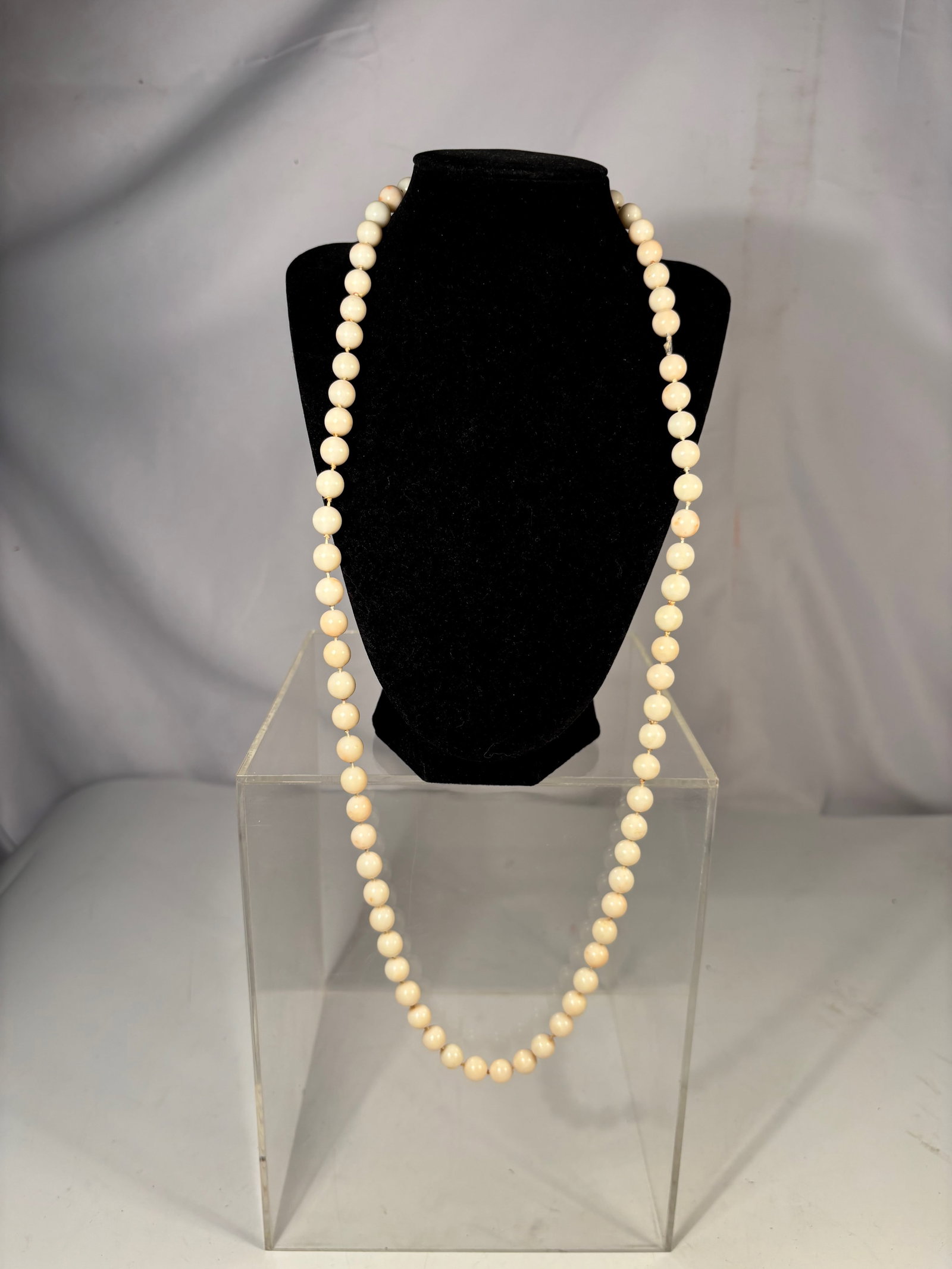 An Angel Skin Coral Bead Necklace, 9.5 mm Beads, 93.8 grams: Strand composed of angel skin coral beads displaying soft creamy pink to pale peach tones characteristic of this coral variety. The beads are polished and hand-knotted between each bead, forming a sub