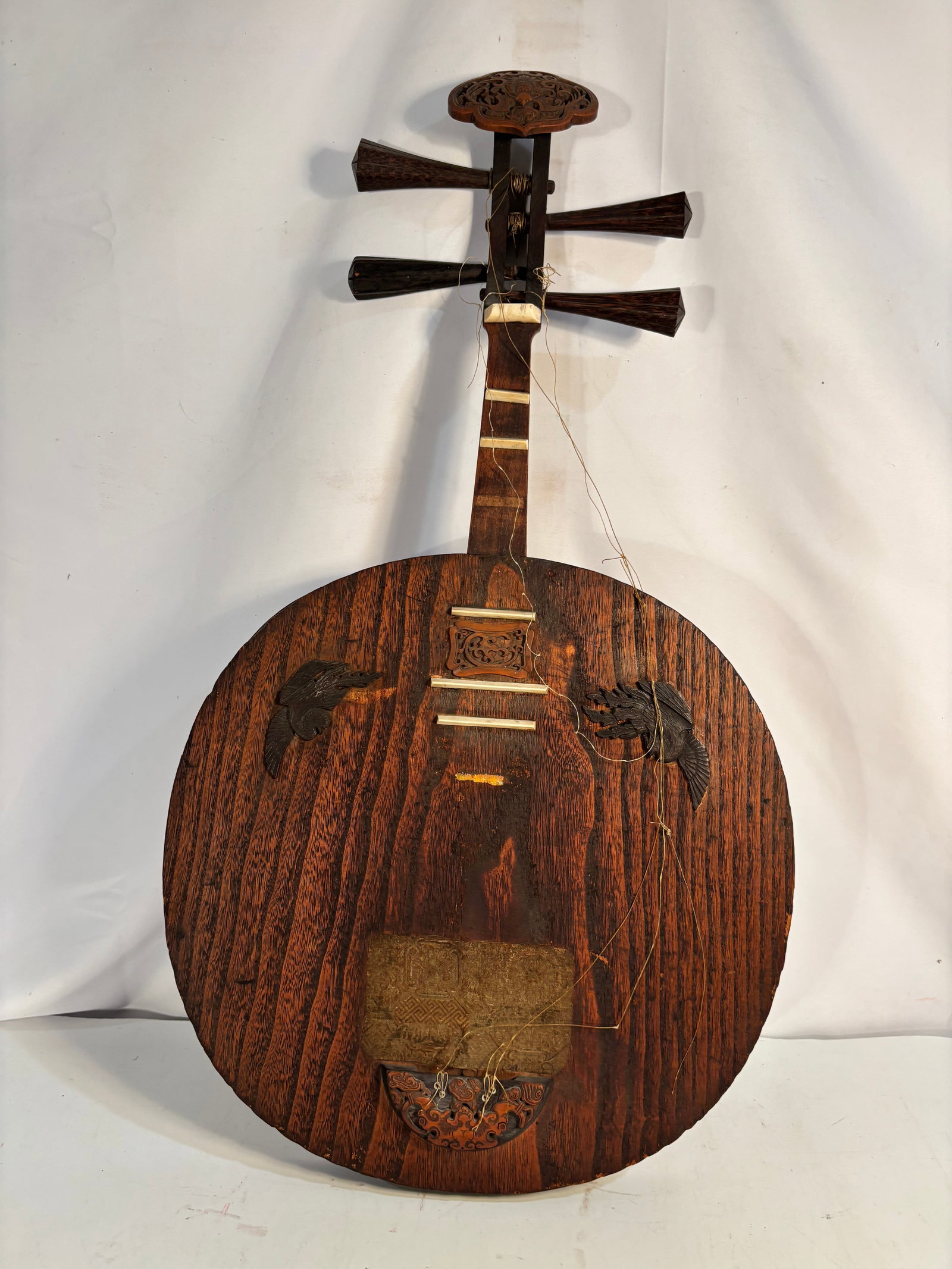 Chinese Carved and Inlaid Yueqin Moon Lute Qing Dynasty (1644-1912): An antique Chinese yueqin, or “moon lute,” . Featuring a circular hardwood resonating body, four large tuning pegs and raised frets, elaborately decorated with pierced and relief-carved phoeni