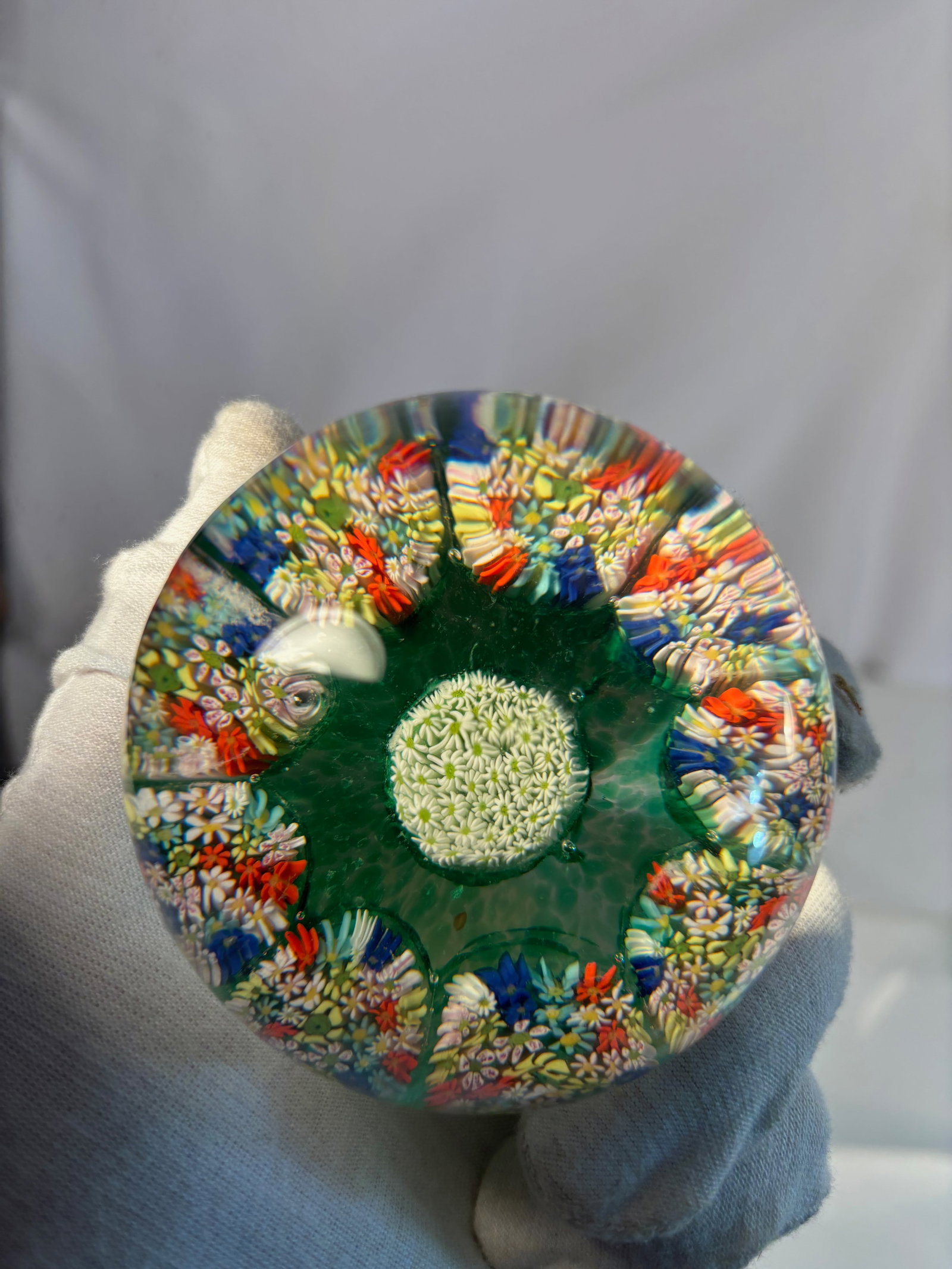 Murano Millefiori Paperweight with Concentric Canes, Green Ground, c.1950s–70s: A vintage concentric millefiori glass paperweight, likely Murano, mid-20th century. The clear dome encases a vibrant arrangement of multicolored canes—red, white, blue, and yellow—set in a circula
