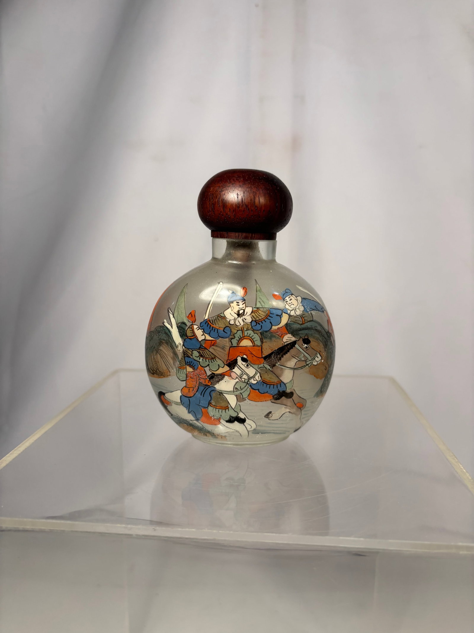 Chinese Inside-Painted Glass Snuff Bottle with Warriors, “China?? Marked Late 19th century: A vintage Chinese inside-painted glass snuff bottle depicting armored warriors on horseback within a landscape. Fitted with a carved wood stopper. Incised “China” mark to the underside. Height