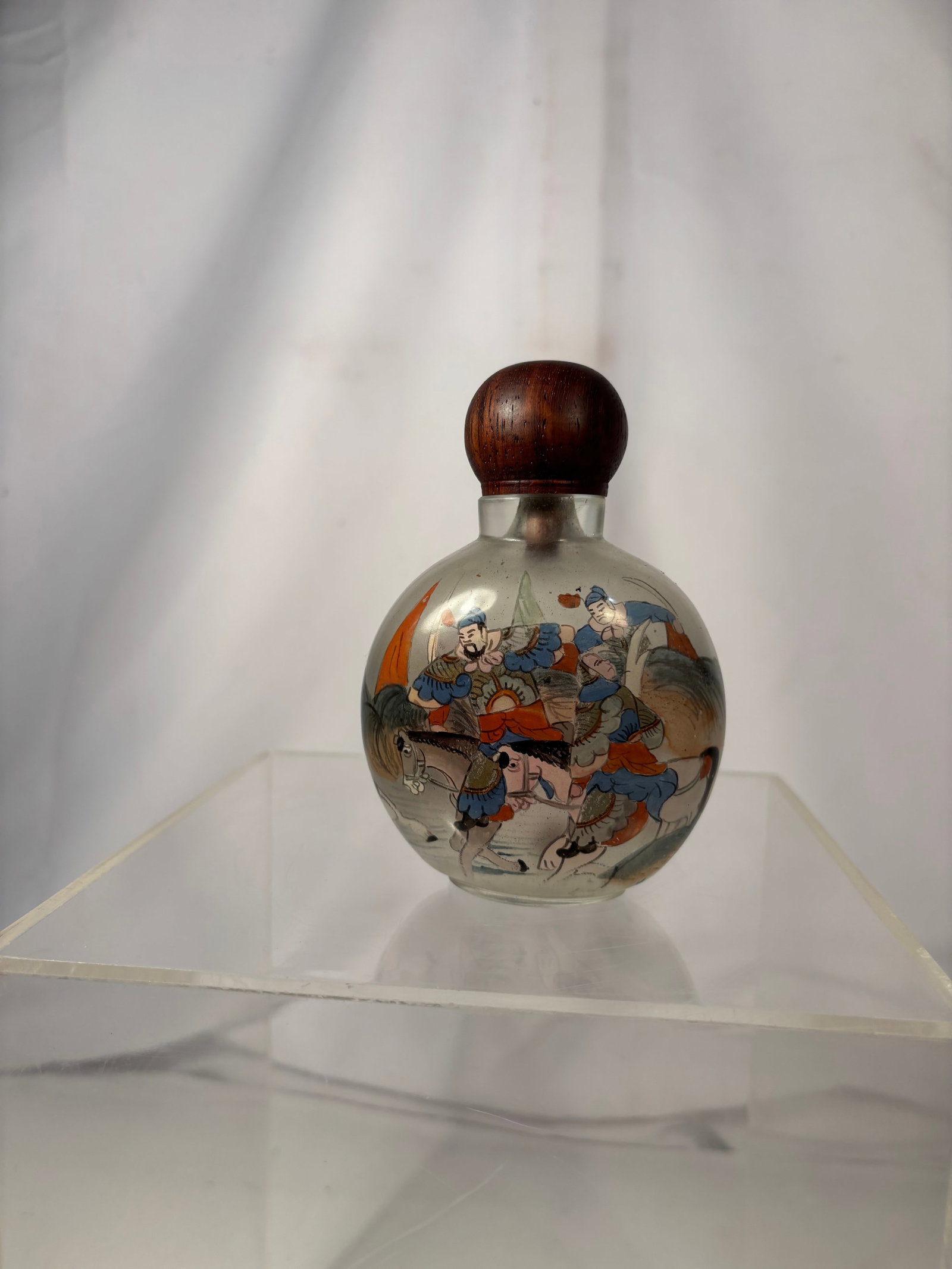 Chinese Inside-Painted Glass Snuff Bottle with Warriors, “China?? Marked Late 19th century: A vintage Chinese inside-painted glass snuff bottle depicting armored warriors on horseback within a landscape. Fitted with a carved wood stopper. Incised “China” mark to the underside. Height