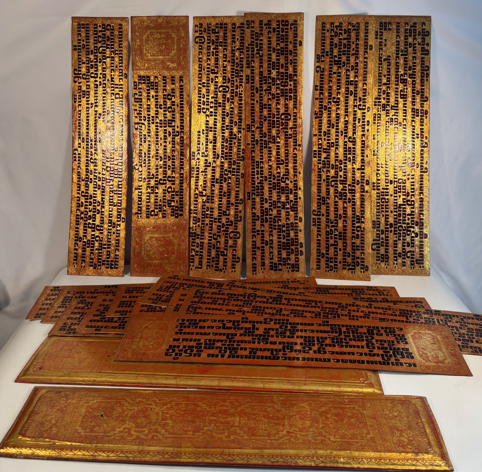 Complete Burmese Gilt-Lacquer Palm-Leaf Manuscript (Kammav?ca), 18 Leaves Including Two Covers,: Late 18th–19th Century, a complete Buddhist palm-leaf manuscript (Kammav?ca) comprising sixteen text leaves and two covers, each richly decorated in gilt and red lacquer. The front and back covers e