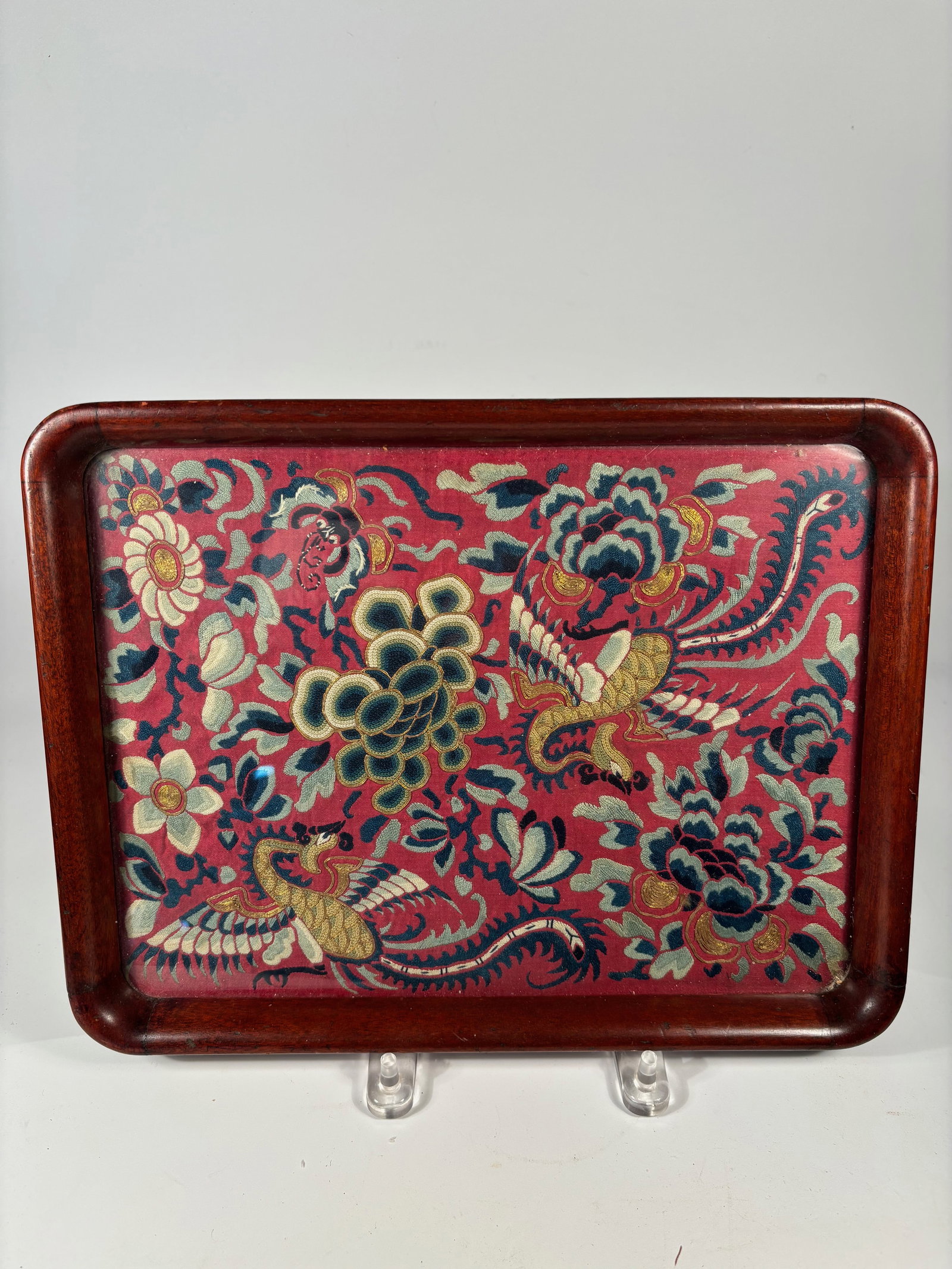 A Fine Chinese Silk Embroidery Fragment with Phoenix and Floral Motifs: Qing Dynasty(1644-1912); A rectangular Chinese lacquered wood tray featuring a vivid hand-embroidered silk panel inset to the base. The embroidery is finely worked with colorful silk and couched gold-