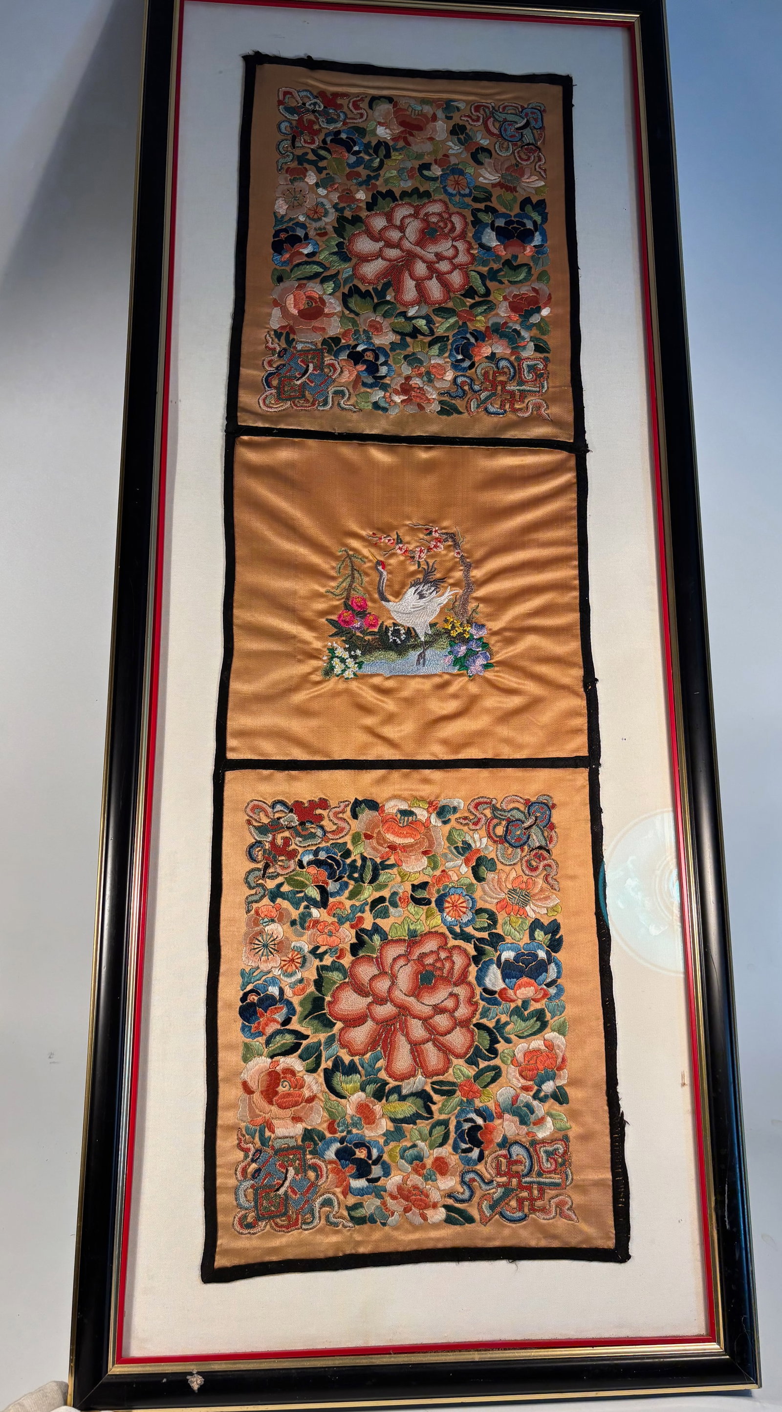 Set of Three Chinese Qing Dynasty Embroidered Silk Panels: Qing Dynasty(1644-1912); A vertical framed arrangement of three finely embroidered silk panels, Qing dynasty or early Republic period, each on a golden ground. The central panel depicts a white crane 
