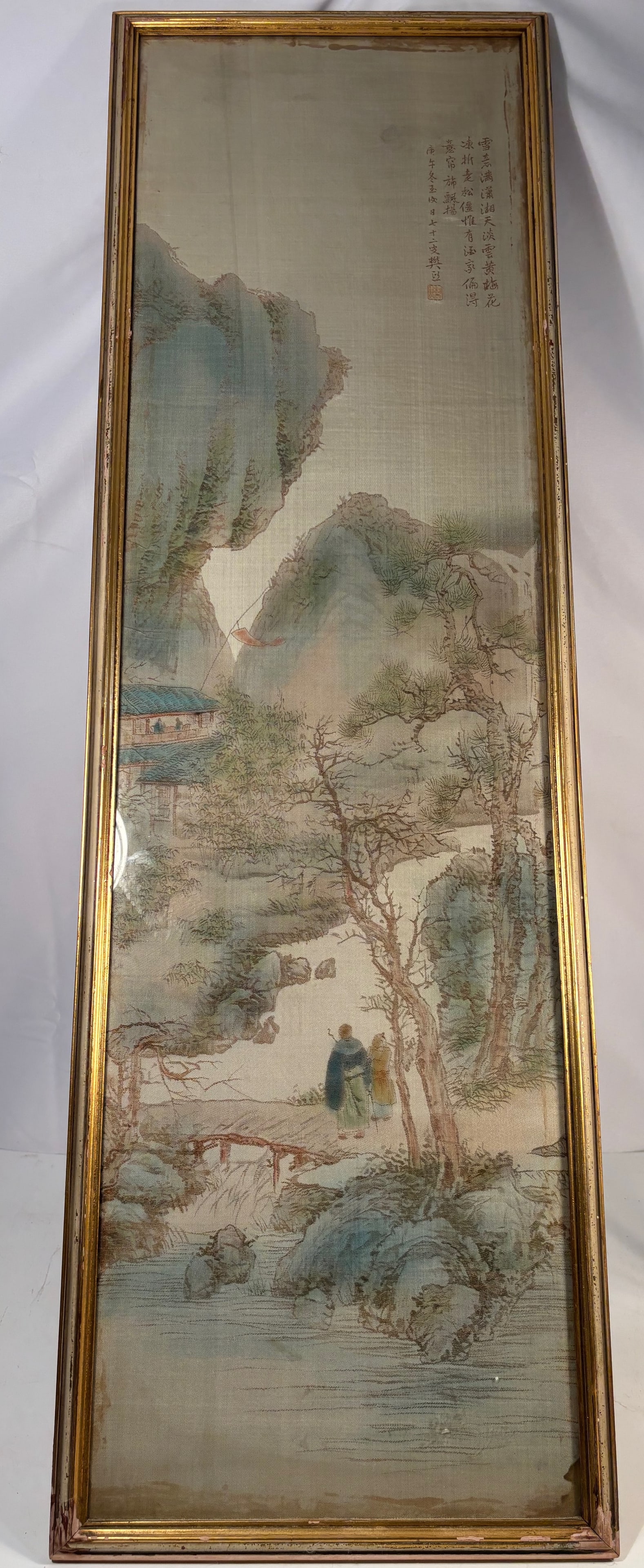Chinese Silk Embroidery Landscape with Scholar, Inscribed and Signed Fan Xi: Finely executed silk embroidery depicting a scholar and attendant walking along a riverside path beneath towering mountains and leafless trees. The landscape is rendered in soft blue, green, and brown