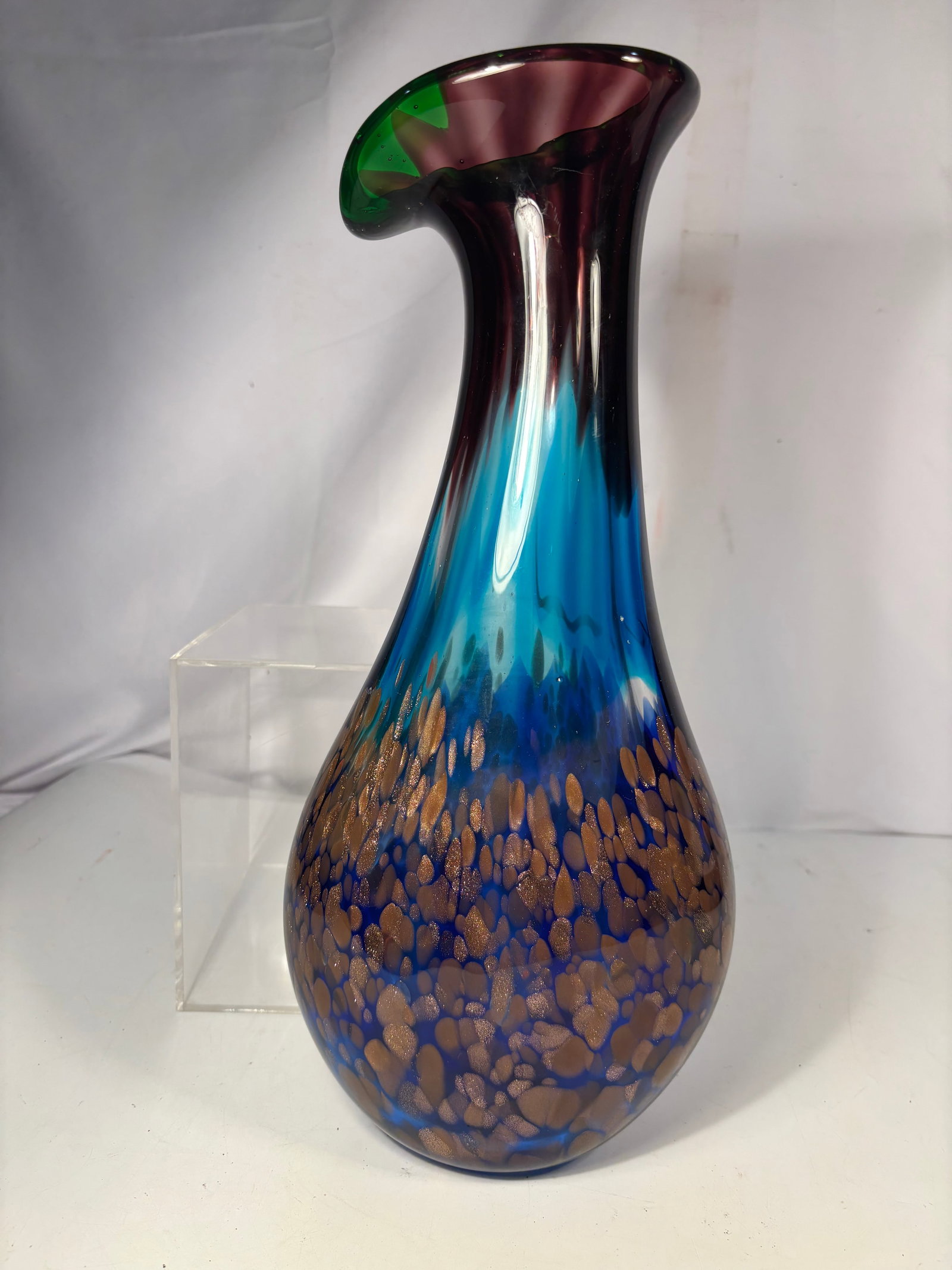 Murano-Style Hand Blown Blue Art Glass Vase with Gold Aventurine: Elegant Murano-style hand-blown art glass vase featuring a tall, slender neck rising from a bulbous body with a dramatic asymmetrical flared rim. The vase showcases a vibrant cobalt and turquoise blue