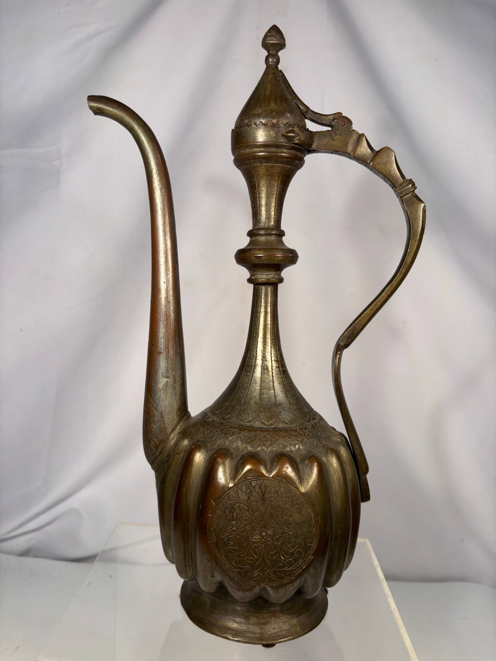 Vintage Persian Engraved Brass Ewer, Marked “IRAN (PERSIA)?? Pattern No. 2908: Vintage Persian brass ewer featuring a tall, slender neck, elongated curved spout, and ornate scroll handle with a hinged domed lid. The lobed body is decorated with finely engraved floral and foliate