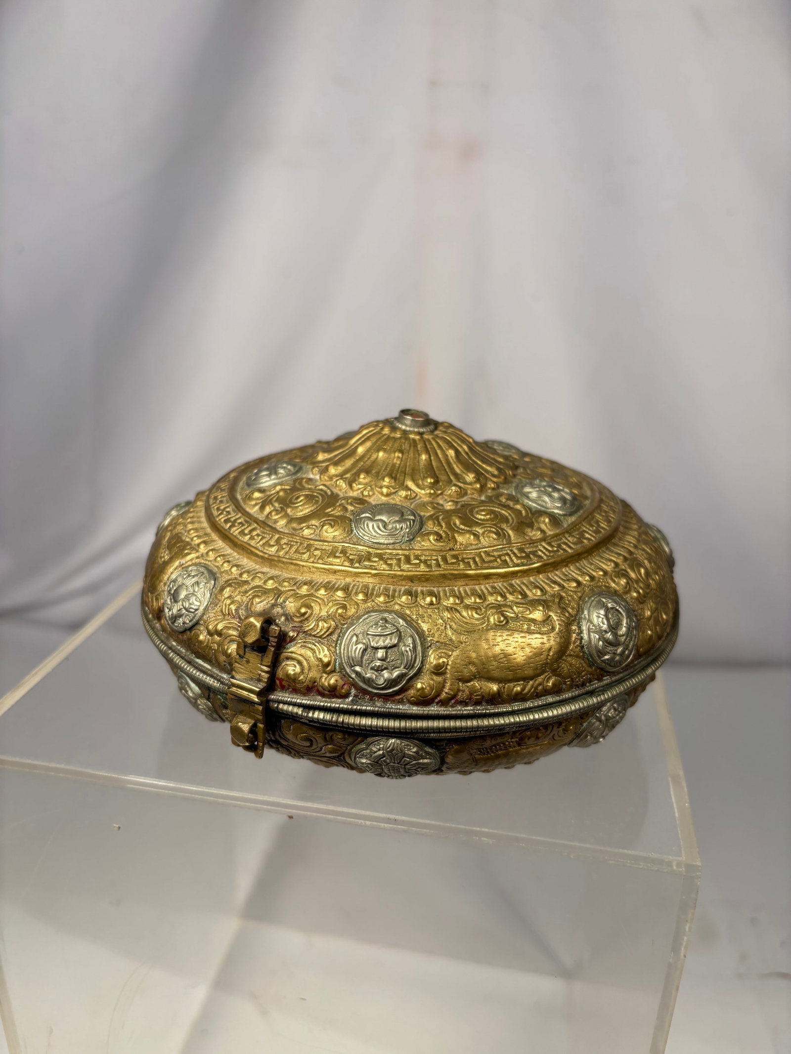 Antique Tibetan Gilt Metal Oval Gau Shrine Box, Repoussé Buddhist Motifs: Antique Tibetan gilt metal oval gau (ga’u) reliquary amulet box, richly decorated in repoussé and chased relief with scrolling floral motifs and medallions. The domed lid and body feature tradition