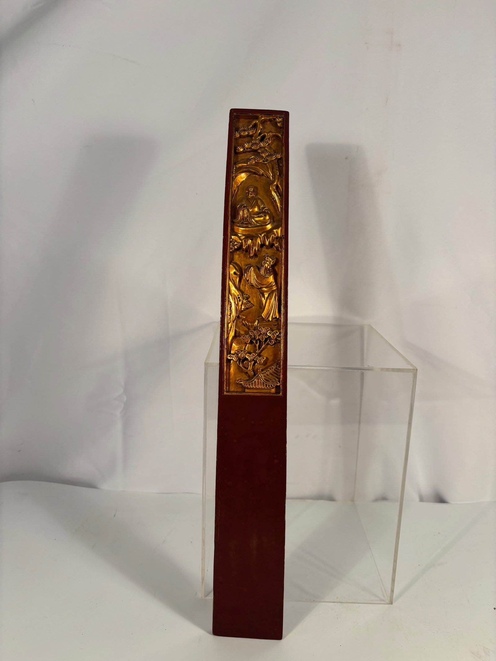 A Chinese Gilt and Lacquered Wooden Court Tablet (Hu Board): Qing dynasty(1644-1912); A finely carved and gilt-lacquered wooden Hu (court tablet) depicting a sage seated beneath pine and rockwork, attended by a standing figure below. The detailed relief scene c
