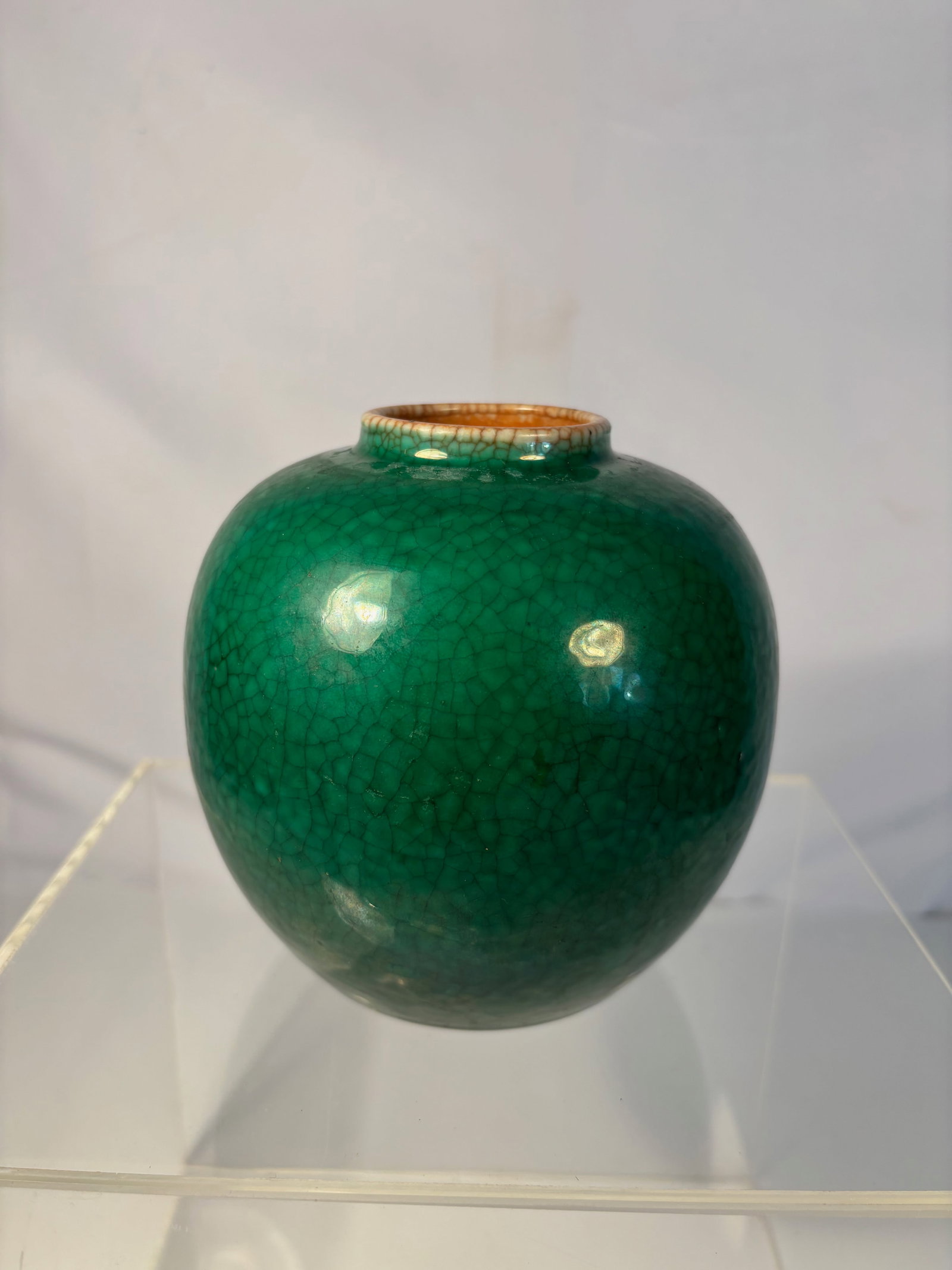 A Chinese Green Crackle-Glazed Jar: A Chinese globular porcelain jar covered in a rich emerald-green crackle glaze, the surface displaying an even network of deliberate craquelure in the classic “ge yao” style. The glaze thins s
