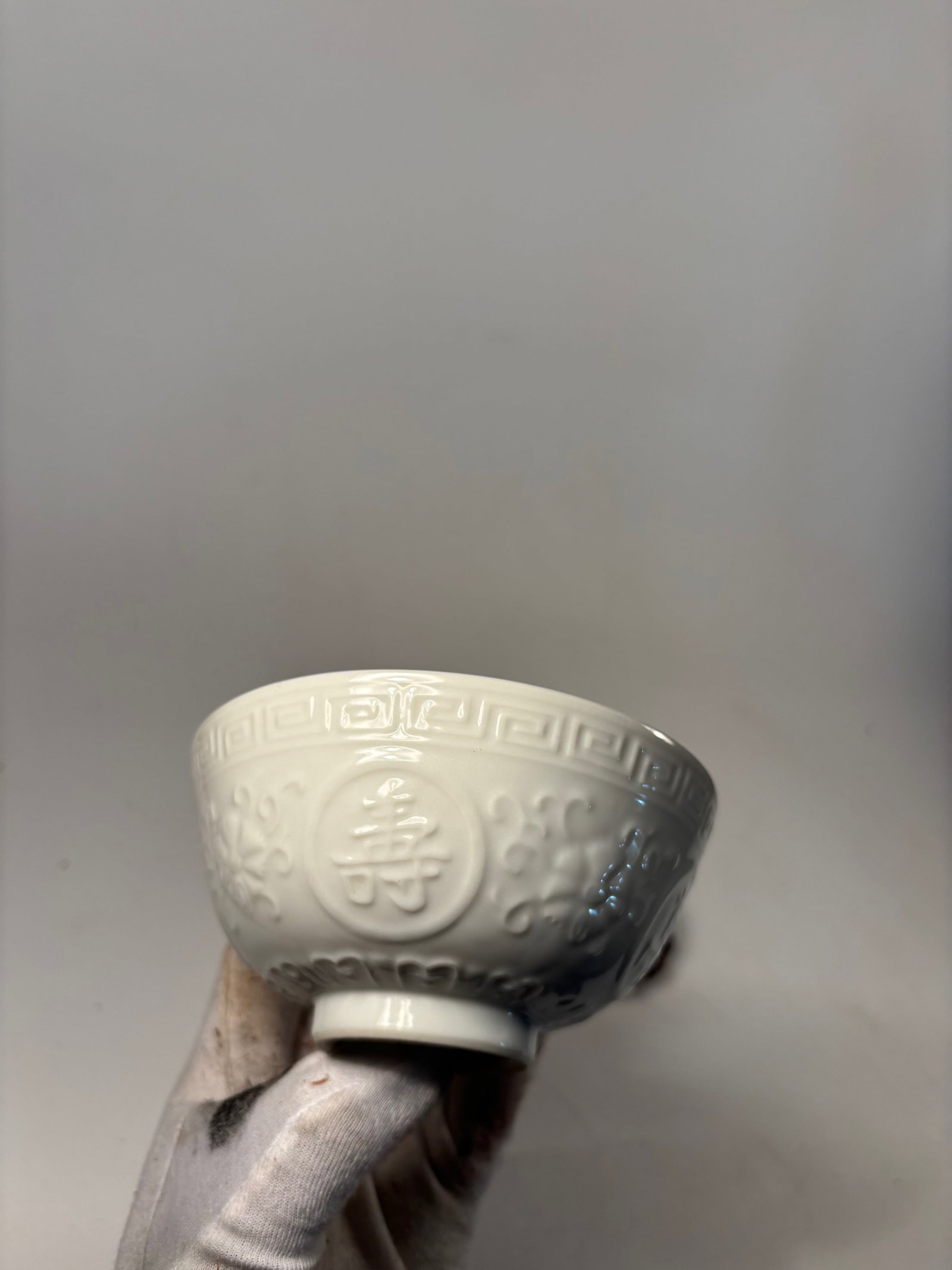 A Chinese Molded White-Glazed Blanc de Chine Porcelain Bowl: Qing dynasty(1644-1912); Molded Chinese phrase "wàn shòu wú ji?ng" for Chinese long life blessing. Dimensions?Height: 2.5 inches; Width: 5.15 inches.