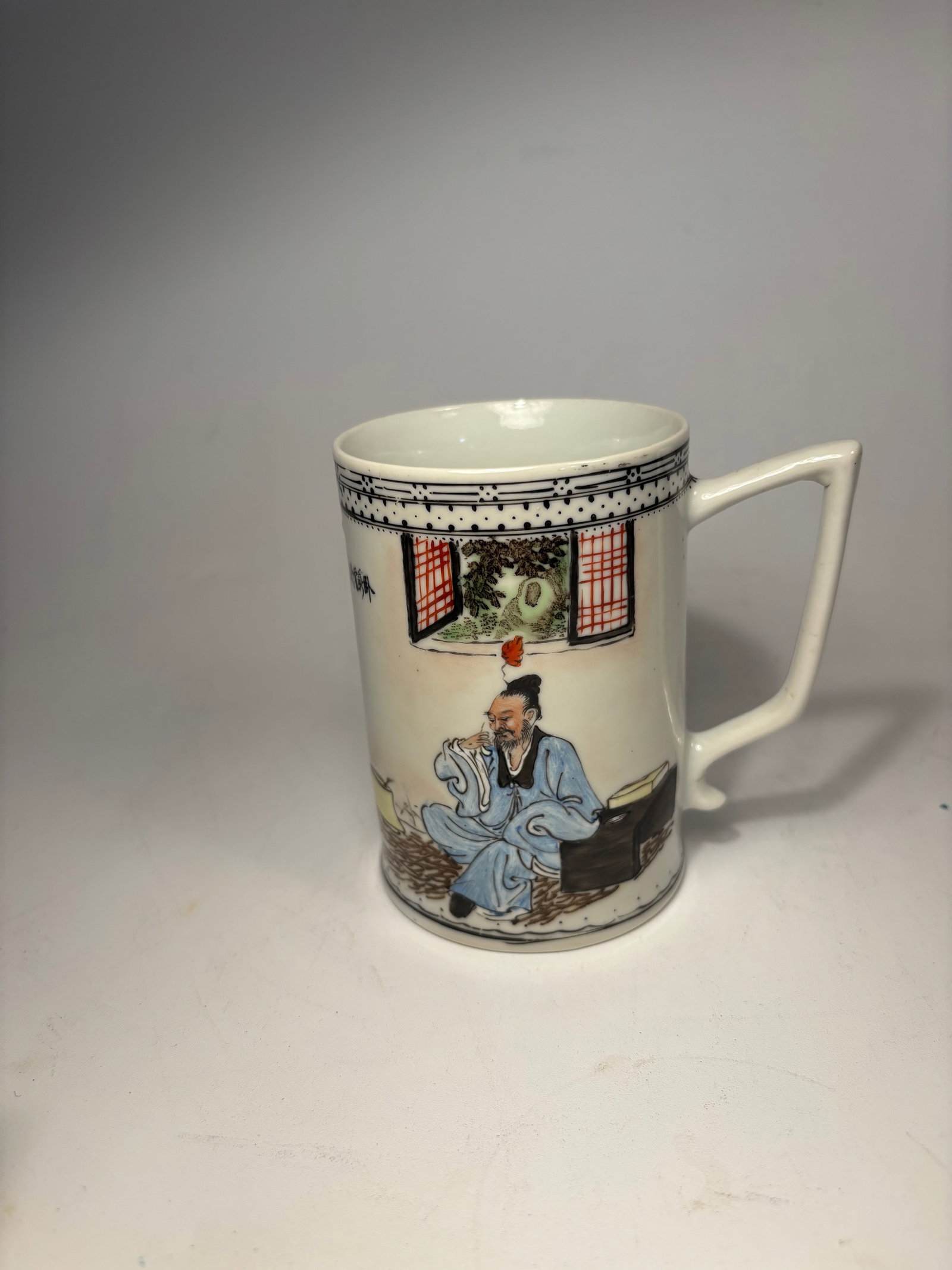 A Chinese famille rose porcelain cup with artist signature"yu di wen ": Republic period (1912-1949) ; This exquisite porcelain mug hails from the Chinese Republic period (circa 1912–1949) and showcases a finely hand-painted depiction of a traditional Chinese scholar ado