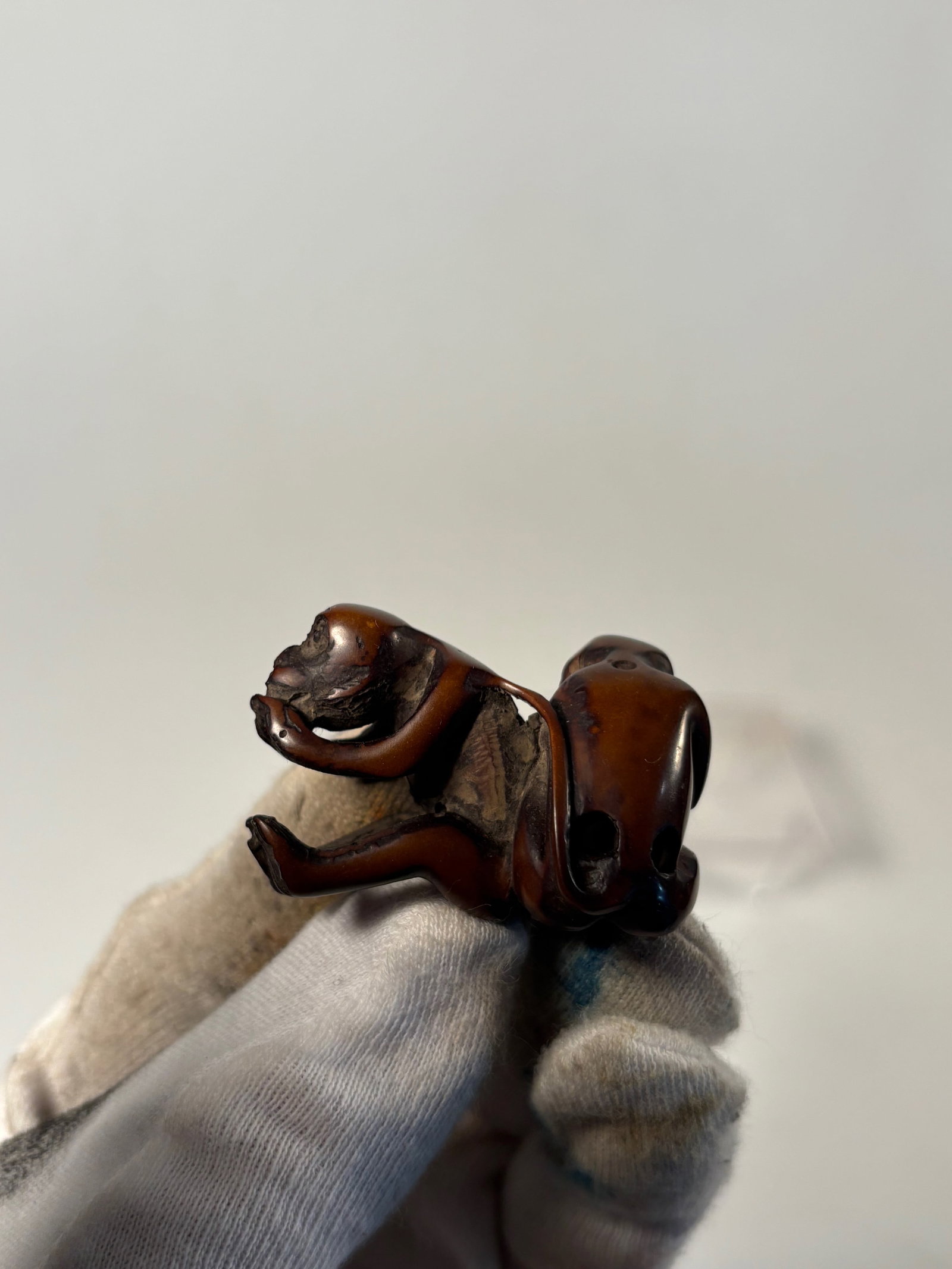 A Japanese Boxwood Netsuke of Two Monkeys: Meiji Period or later (late 19th–early 20th century); Carved from what appears to be boxwood or a similar hardwood with a rich, polished patina, the netsuke features two monkeys, one grooming the ot