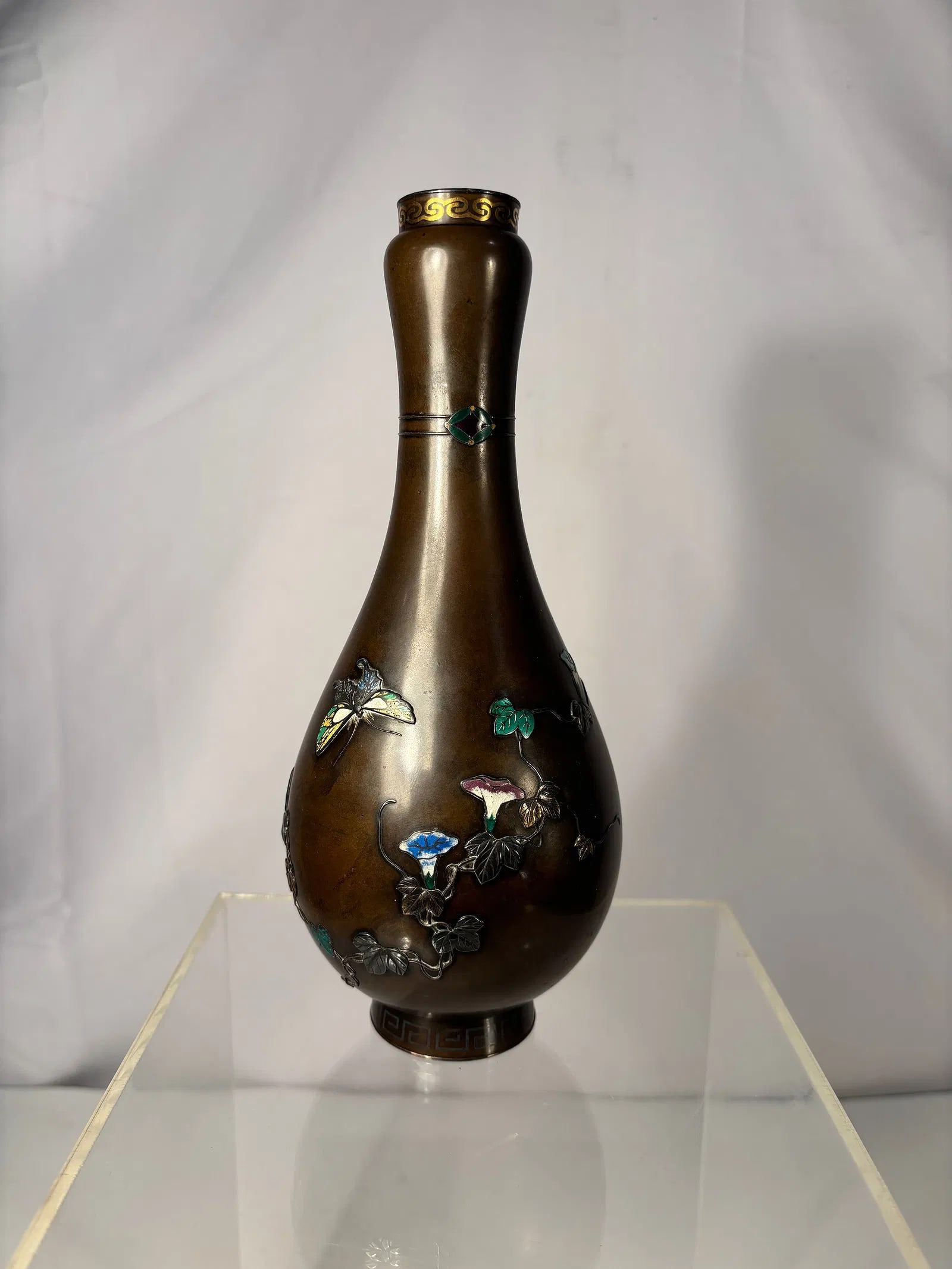 A BRONZE VASE, SIGNED SAITO, MEIJI PERIOD, LATE 19TH CENTURY: The oviform vase with everted neck rounded rim and short collar, decorated in gold and silver takazogan and applied enamel depicting butterflies among flowers and foliage, the collar with band of geom