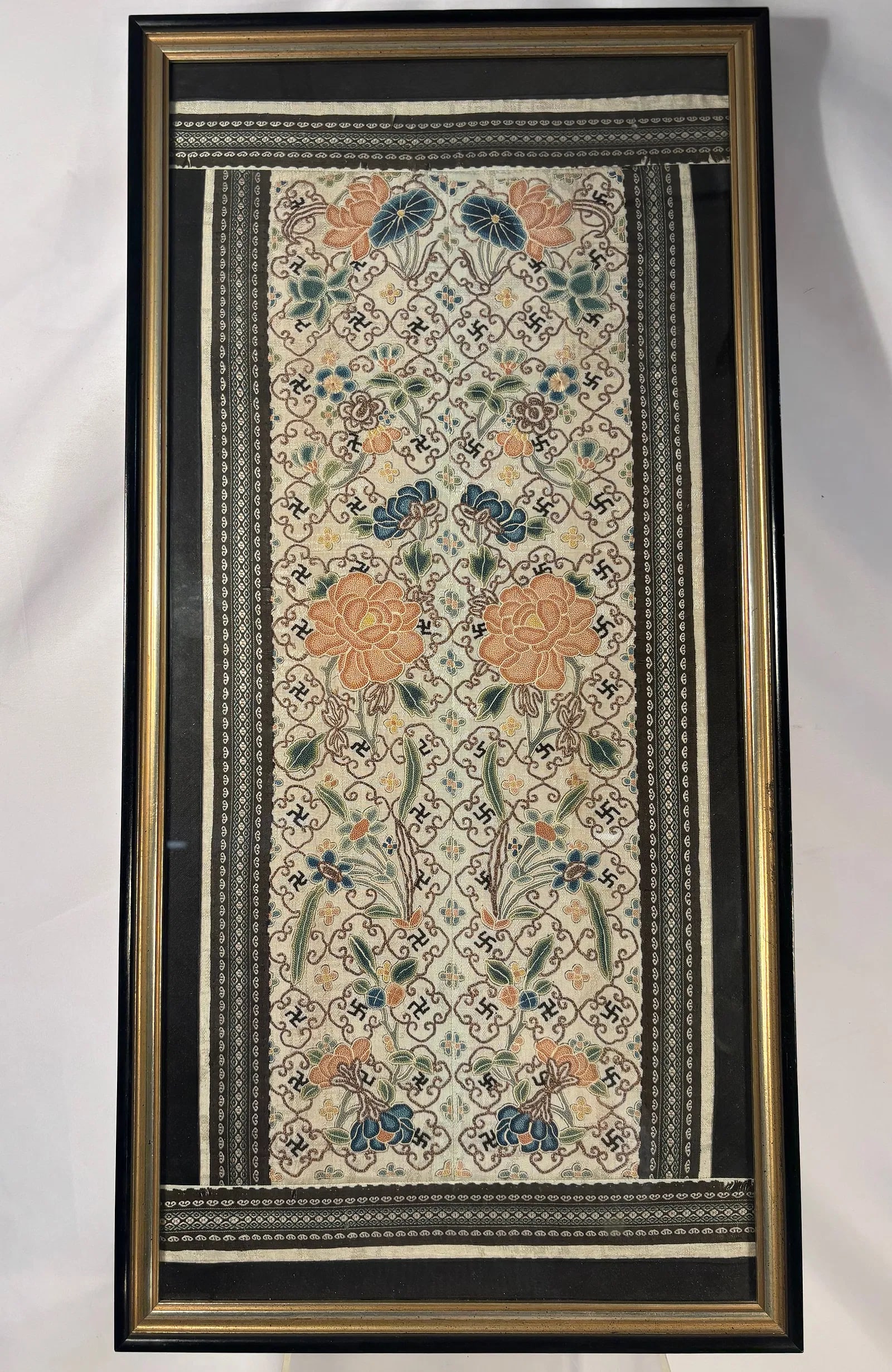 A Chinese Embroidered Silk Panel with Floral and Geometric Motifs: 19th Century, Chinese embroidered silk panel, finely worked with floral scrolls and repeating geometric reserves enclosing auspicious symbols, including Buddhist swastika motifs (?). The design featur