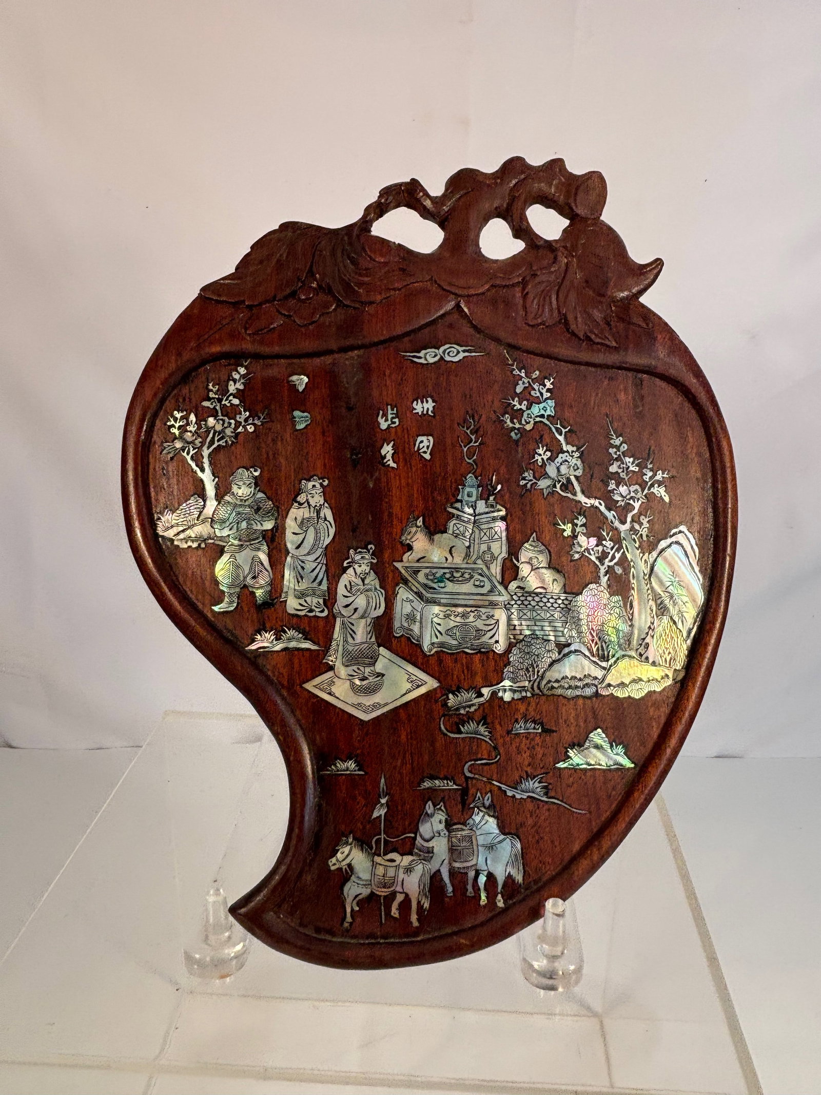 A Chinese Rosewood Plaque with Mother-of-Pearl Inlay of Scholars in Landscape: Late 19th century; A Chinese hardwood panel, late Qing to Republic period, inlaid with mother-of-pearl to depict scholars in a garden landscape, with flowering trees, rockwork, and scholar’s objects