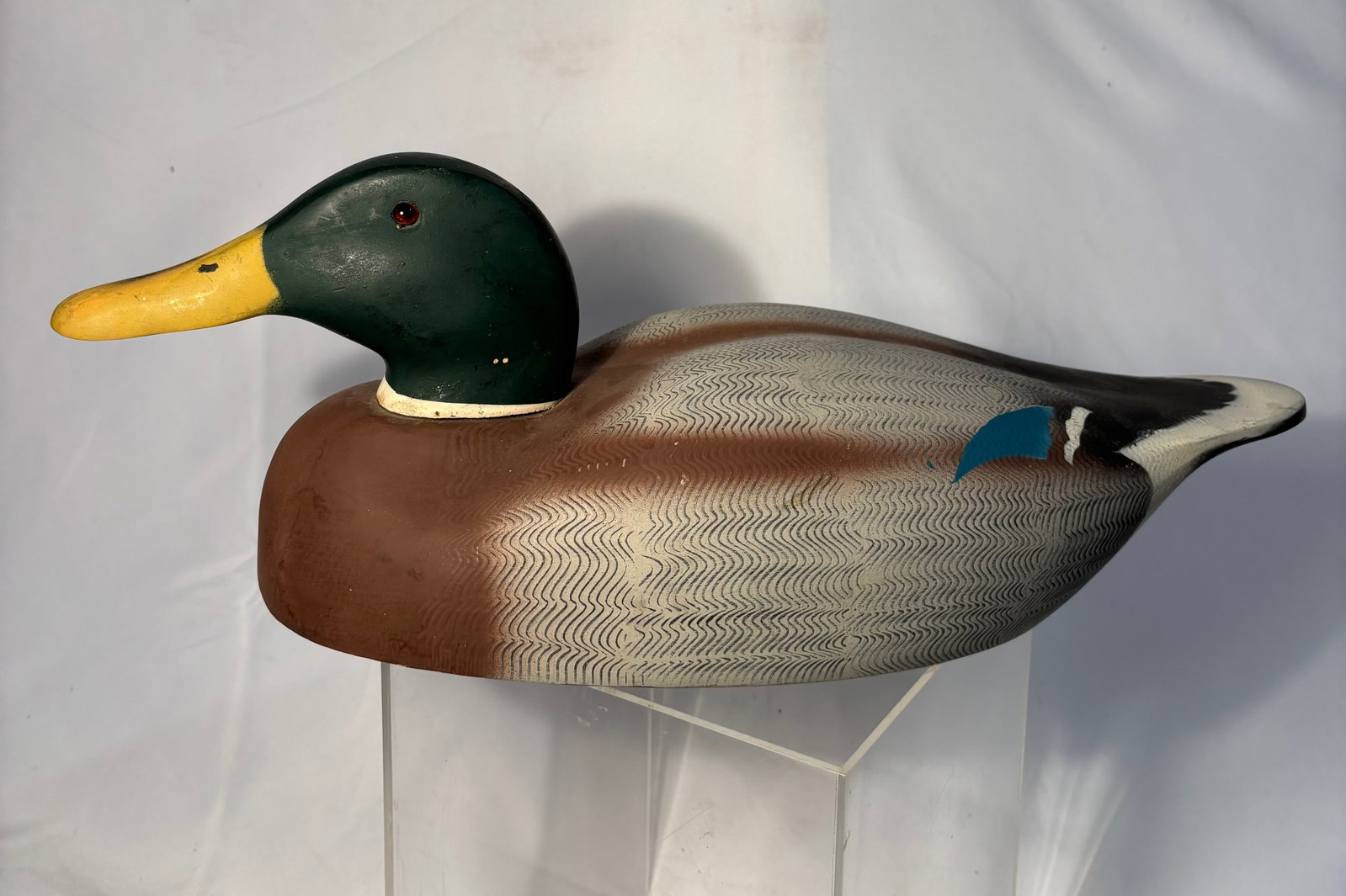 A Mid Century Hand Painted Duck Hunting Decoy by Decoys Unlimited: Vintage hand-painted carved duck decoy bearing “Decoys Unlimited” label for Erie, Pennsylvania. Decorative sporting art example with painted surface and carved form. Length: 18 inches , Width: