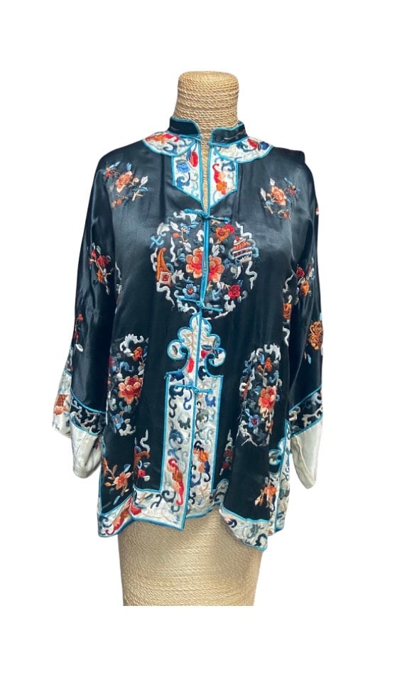 A Chinese Black Silk Embroidered Jacket: Qing Dynasty (1644-1912);A late Qing Dynasty black silk woman’s jacket, finely hand-embroidered with auspicious motifs including peonies, vases, and ruyi scrollwork. Decorated in vibrant satin stitc