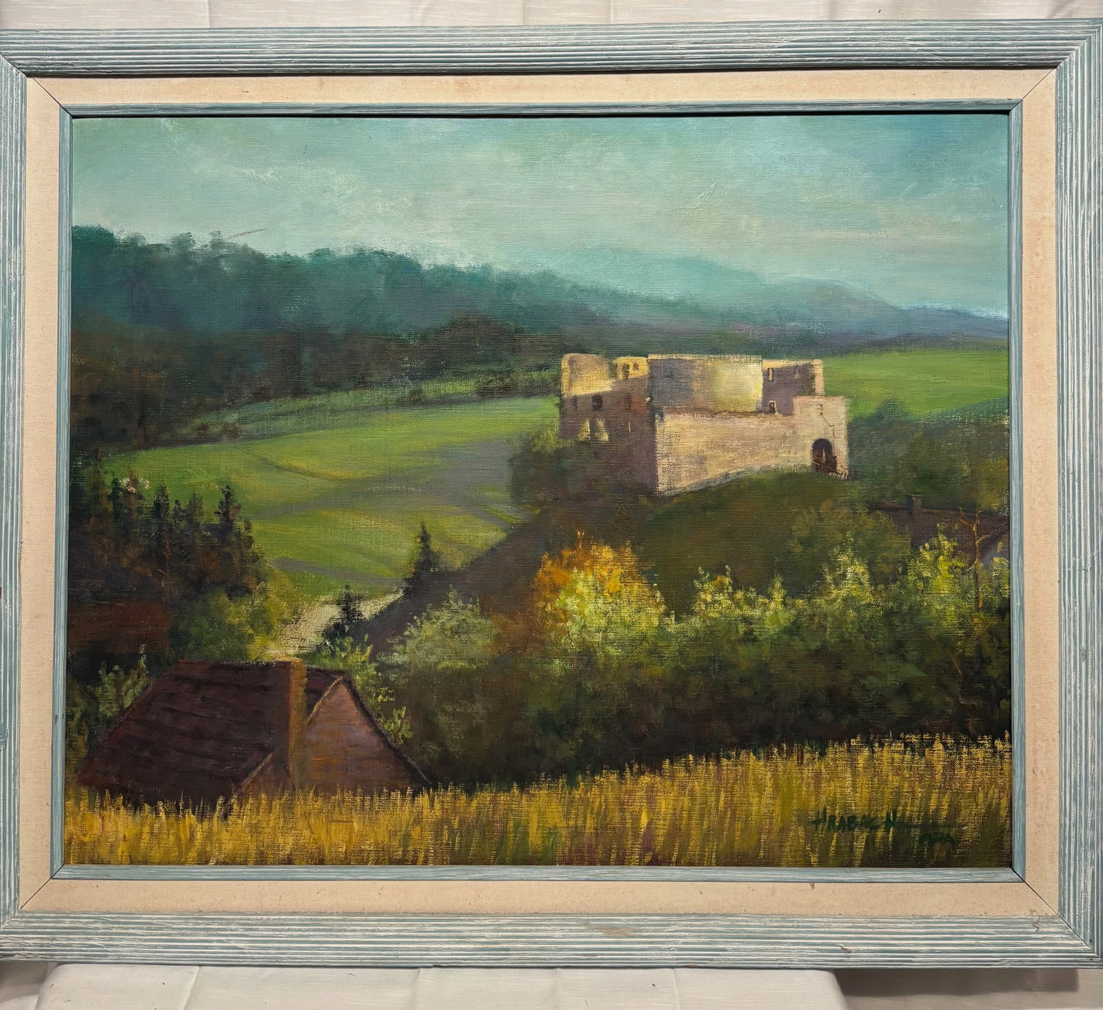 Hraback, Signed European Castle Ruins Landscape on Canvas: Signed by Hraback, this atmospheric landscape depicts a picturesque European countryside with castle ruins set above rolling green fields, wooded hills, and a distant mountain horizon. Warm sunlight