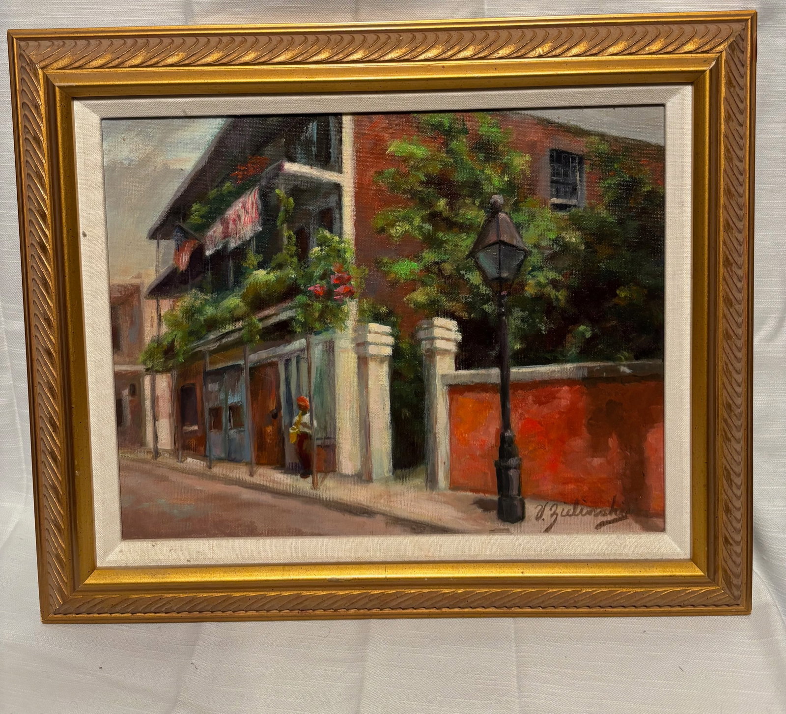 European Street Scene Oil Painting, Signed J. Zielinski, Framed: A charming European street scene oil painting depicting a sunlit architectural corner with balconies, greenery, and a street lamp. Rendered in a soft impressionistic manner with warm tones and texture