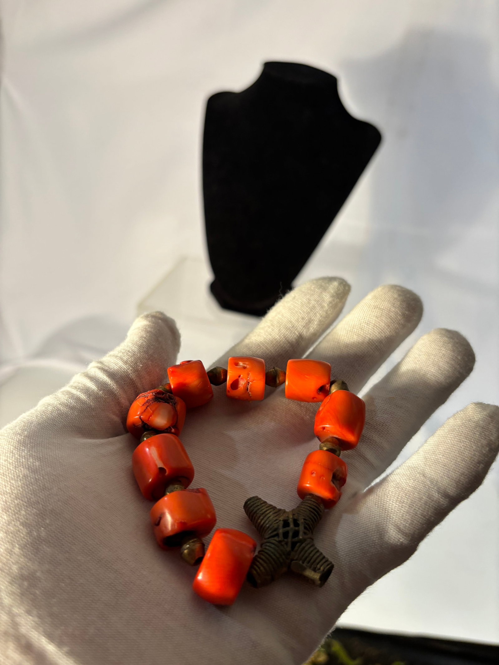 A Vintage Coral Bead Bracelet, Buddhist Prayer Style, Hand-Strung with Ornamental Focal Bead: A striking vintage bracelet composed of bold coral beads, hand-strung in a rhythmic arrangement of barrel and organically shaped forms. The vivid red tones are enriched by natural variations in surfac