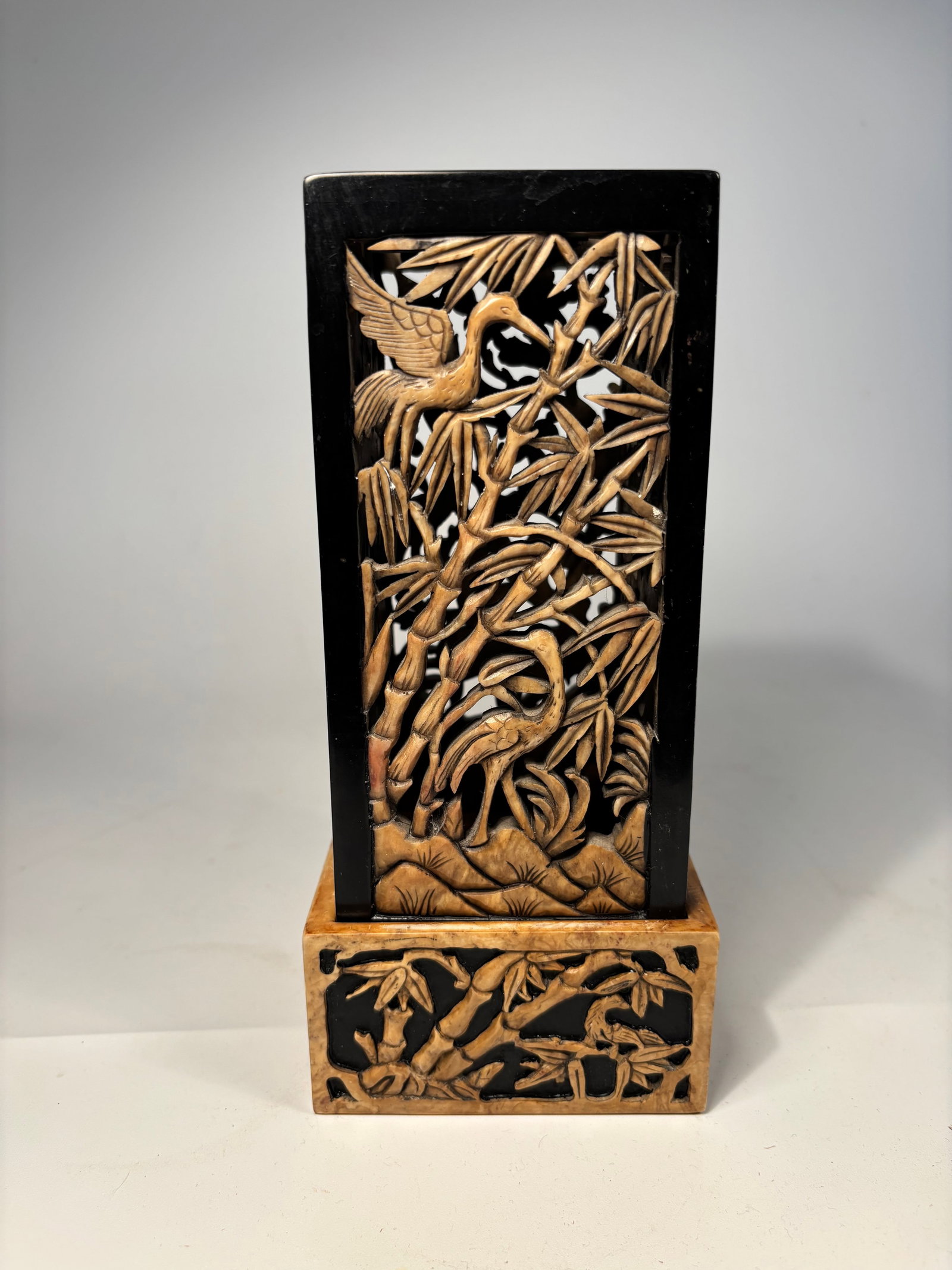 A Chinese hand carved soapstone candle holder/ incense burner: Early 20th century; The pierced caving is delicate ,with motifs (crane, deer, peonies, bamboo....) ?Dimensions?Height: 8 inches; Width: 4 inches.