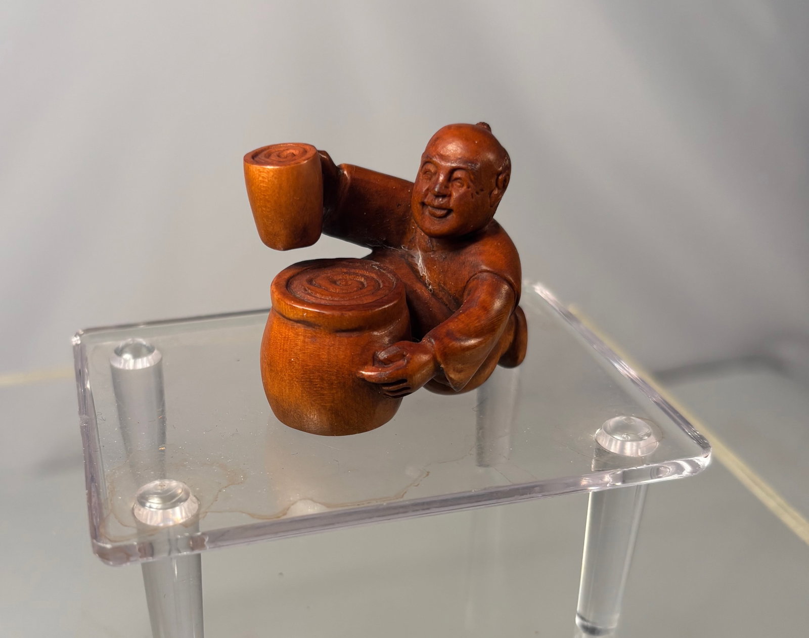A Japanese Boxwood Netsuke of a Standing Farmer Carrying a Hoe, Signed Matsuyama: Meiji period (19th century),Carved Japanese netsuke in boxwood depicting a standing farmer carrying a hoe slung over his shoulder, rendered in a lively and animated pose. The figure wears short workin