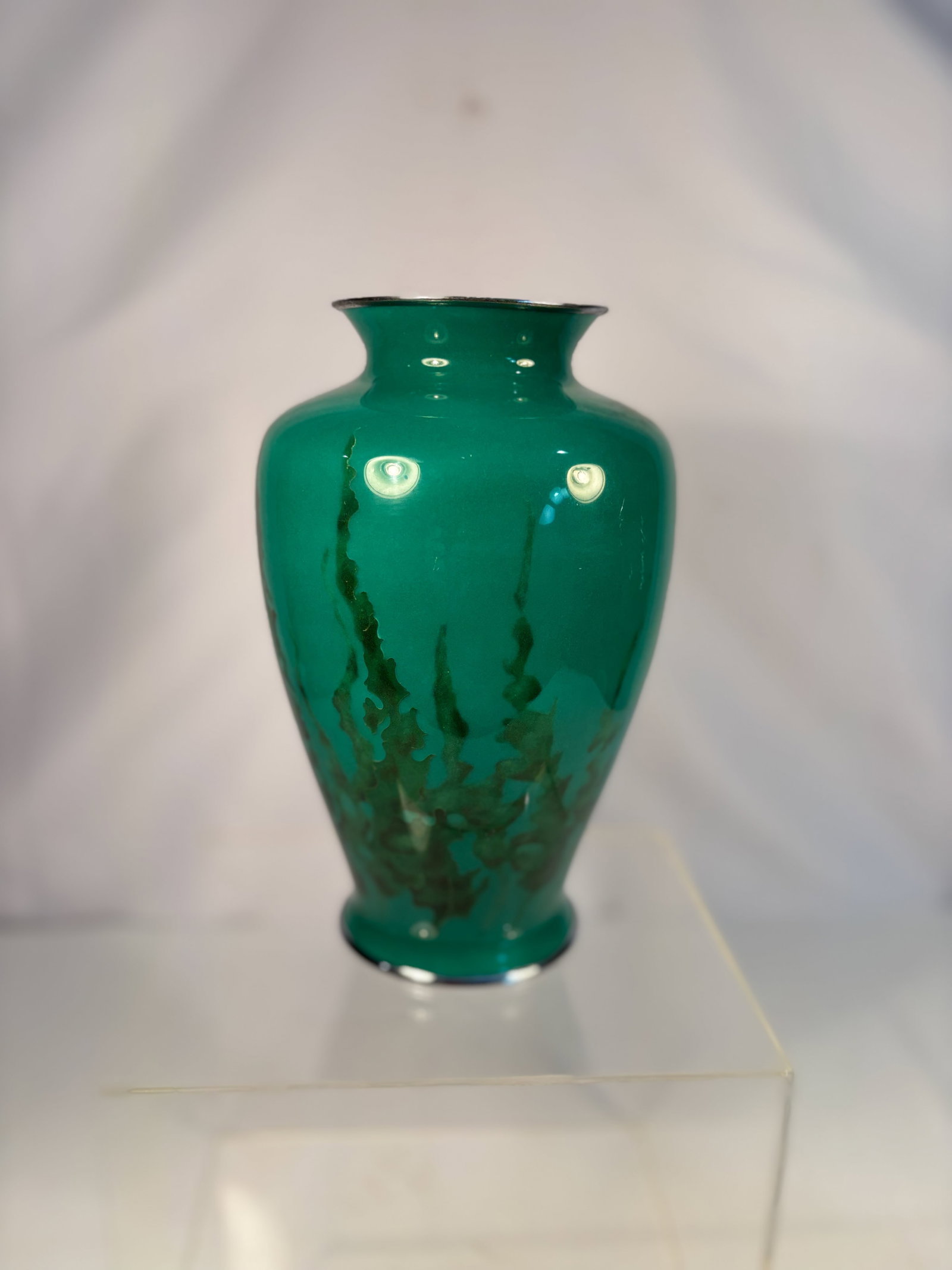 A Japanese Green Cloisonné Enamel Vase on Bronze: Early - mid 20th century; Of baluster form with gently flaring mouth and foot, the bronze body decorated in a translucent emerald-green enamel with deeper green veining toward the base, evoking styliz