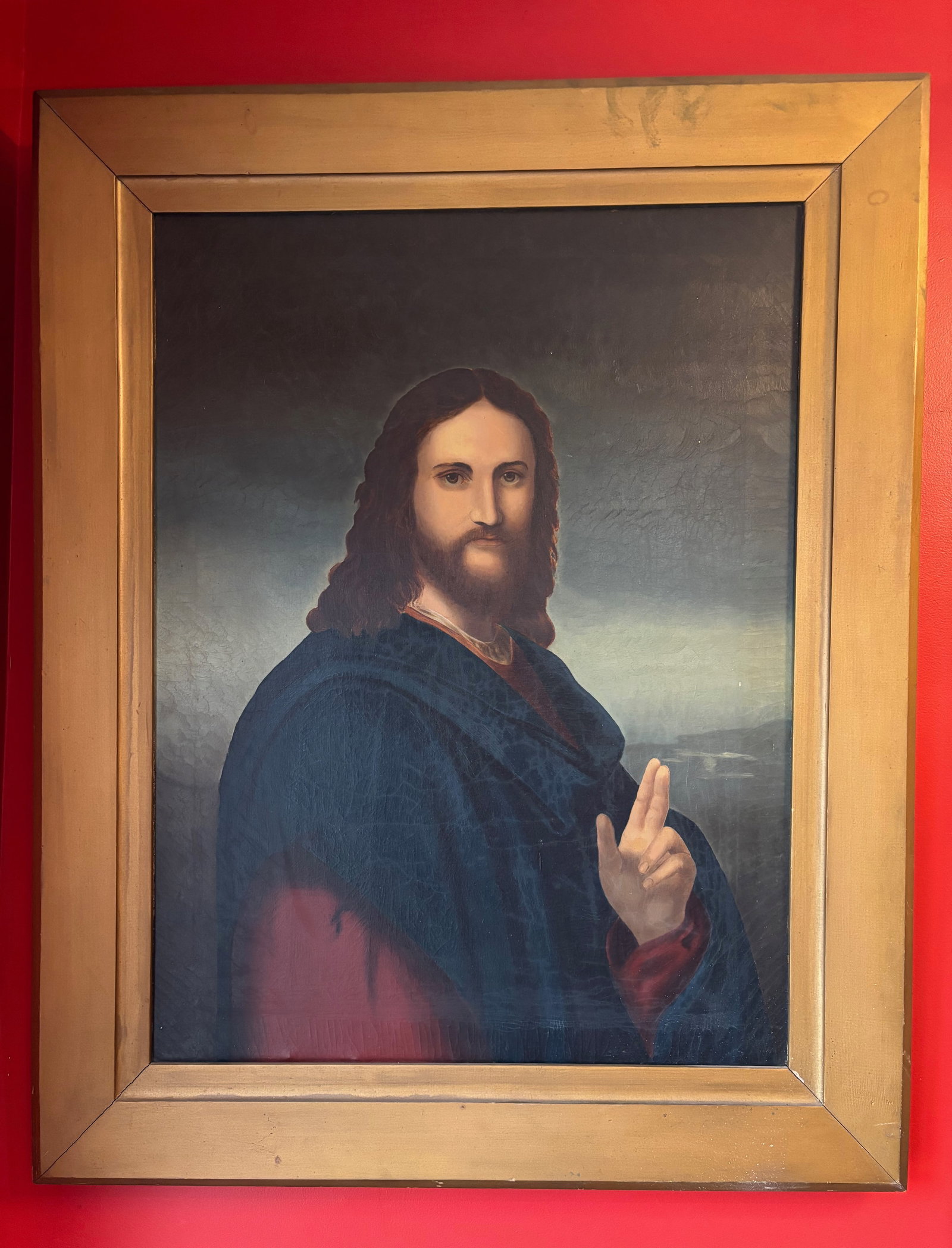 Large 19th Century Christ Portrait Oil Painting: Large oil on canvas devotional portrait depicting Christ with long flowing hair and beard, raising his right hand in a traditional gesture of blessing. The figure is dressed in a deep blue robe agains
