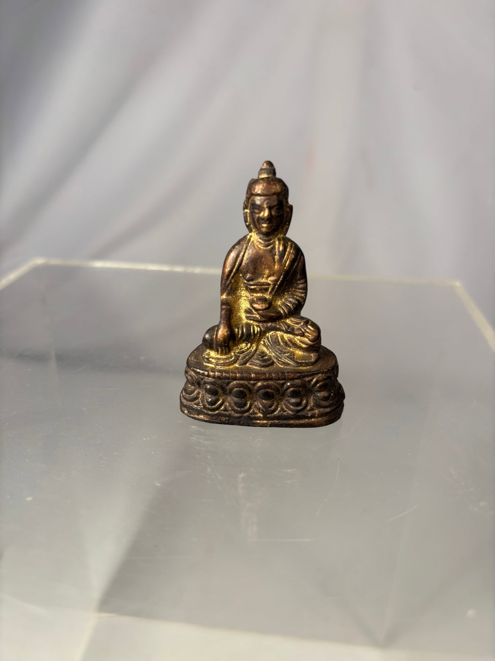 Tibetan Gilt-Bronze Figure of Shakyamuni Buddha 19th century: A 19th-century Tibetan gilt-bronze figure of Shakyamuni Buddha, depicted seated in dhyanasana on a double-lotus pedestal. His right hand is lowered in the earth-touching bhumisparsha mudra, while his 