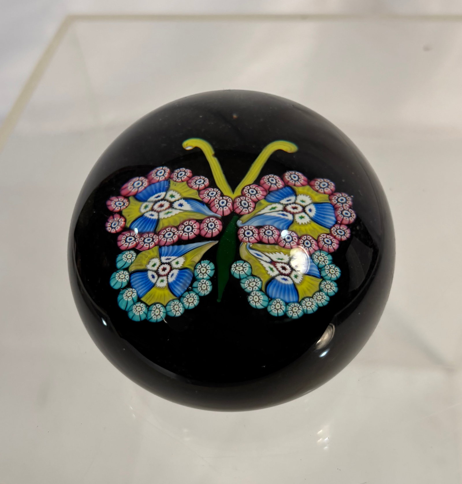 Scottish Millefiori Butterfly Art Glass Paperweight, Attributed to Paul Ysart (SCOTTISH, 1904-1979): A Scottish studio art glass paperweight attributed to Paul Ysart, featuring a colorful millefiori butterfly composed of intricate pink, turquoise, blue, yellow, and white glass canes against an opaque