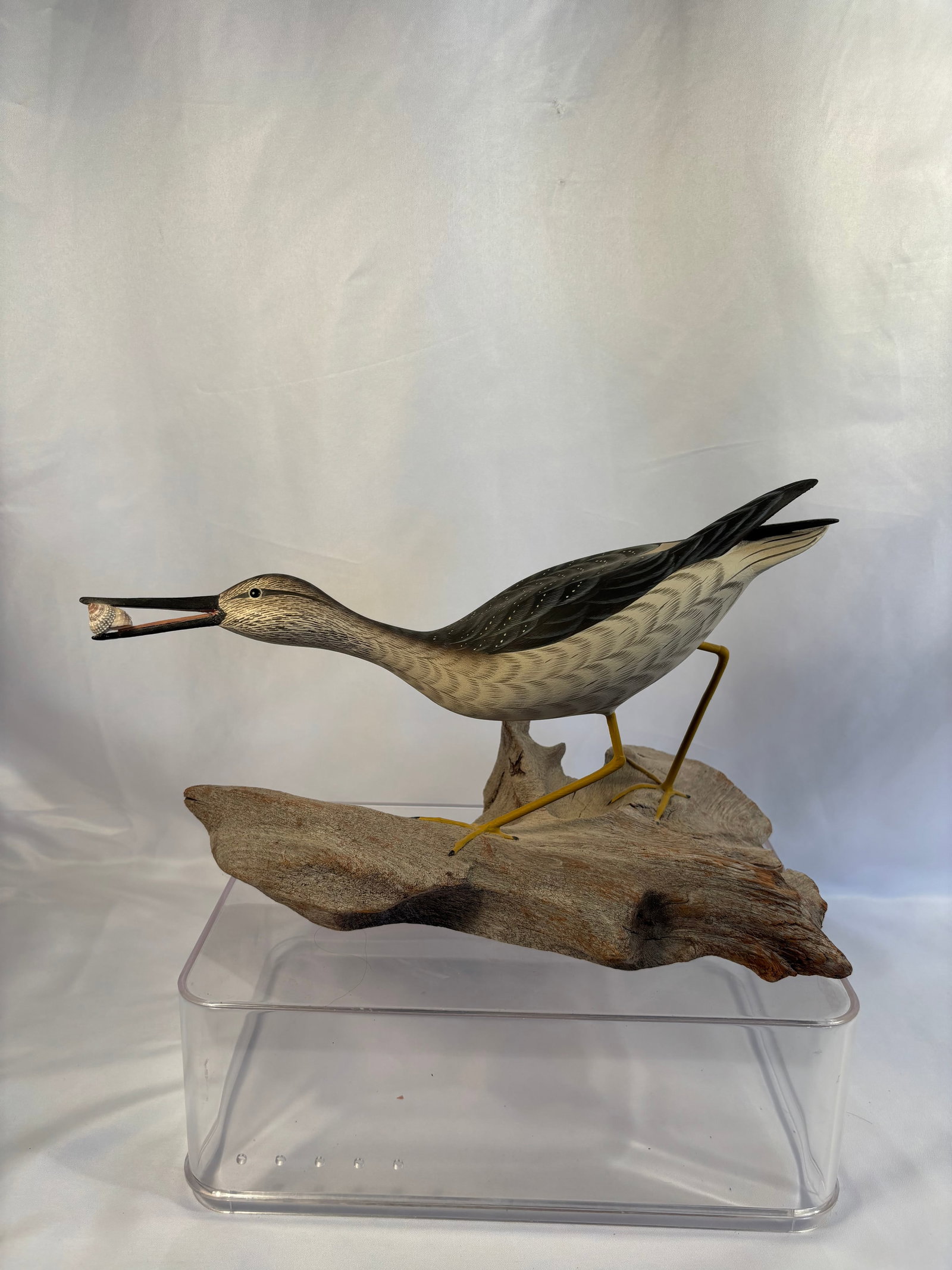 Curtis W. Waterfield (Virginia, 1926–2017) Signed Greater Yellowlegs Shorebird Carving with Shell: Hand-carved and polychrome-painted wooden shorebird, likely depicting a Greater Yellowlegs, modeled in a feeding pose with a small shell held in its open bill. The bird features finely incised feather