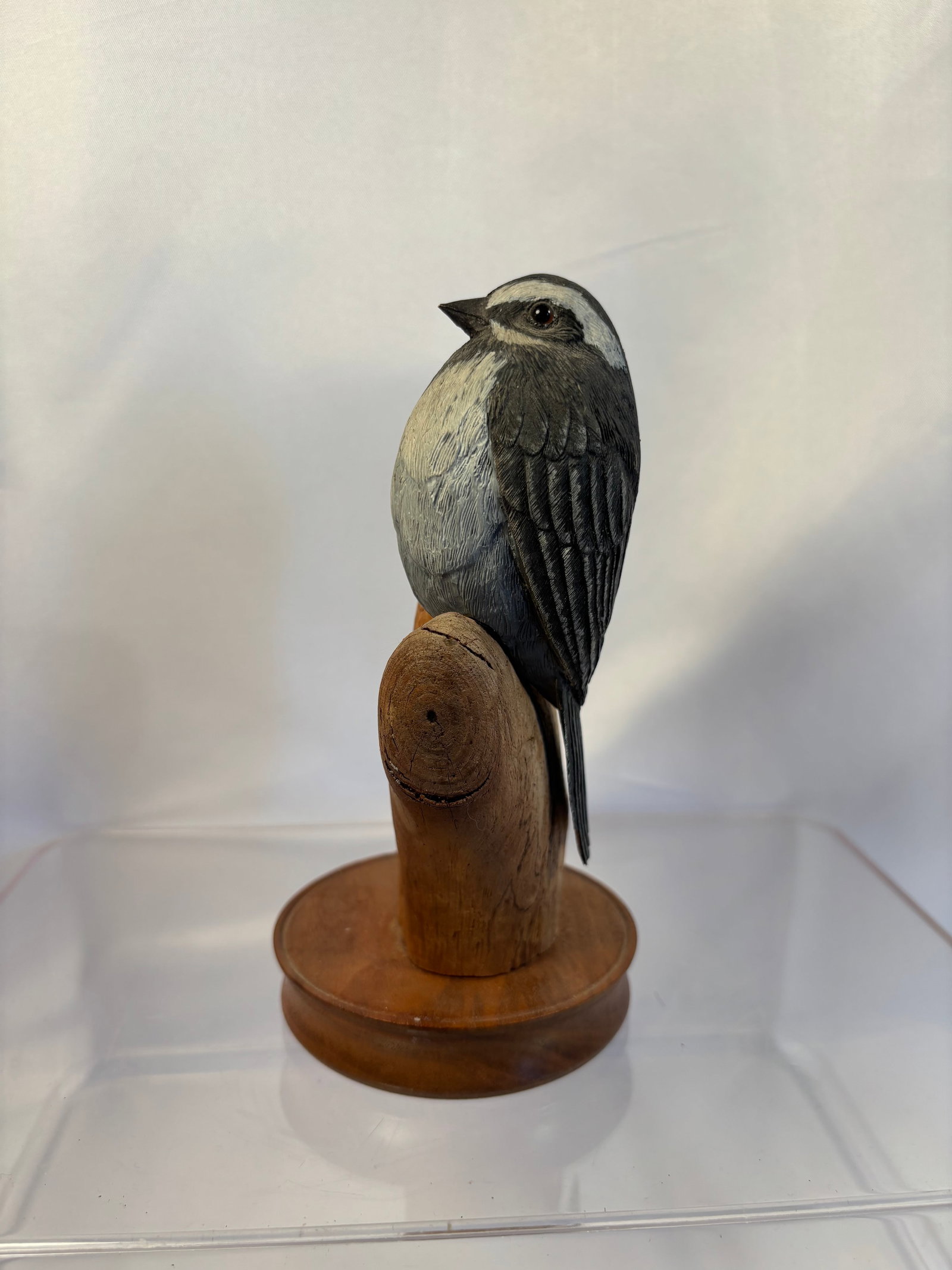 Ken Lawrence Signed 1987 Hand-Carved Black-Throated Gray Warbler Sculpture: A finely hand-carved and hand-painted wooden songbird sculpture depicting a black-throated gray warbler perched on a naturalistic branch, raised on a circular wooden base. Detailed feather carving and