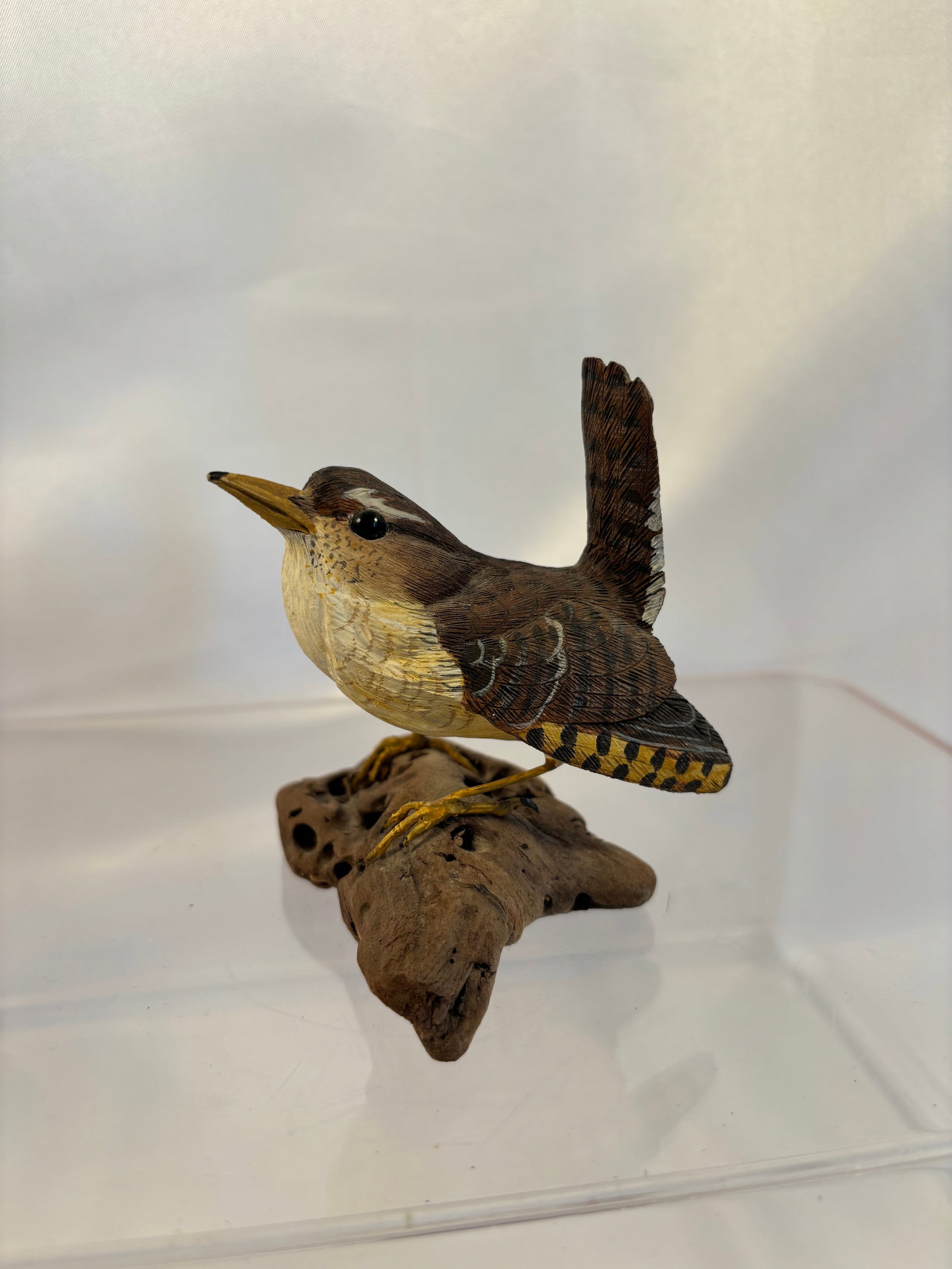 Pete Micciche Signed 1987 Carved and Painted “House Wren?? Bird Sculpture: A finely carved and hand-painted wooden sculpture by American bird carver Pete Micciche, realistically depicting a house wren with raised tail, inset glass eyes and finely detailed plumage. The bird s