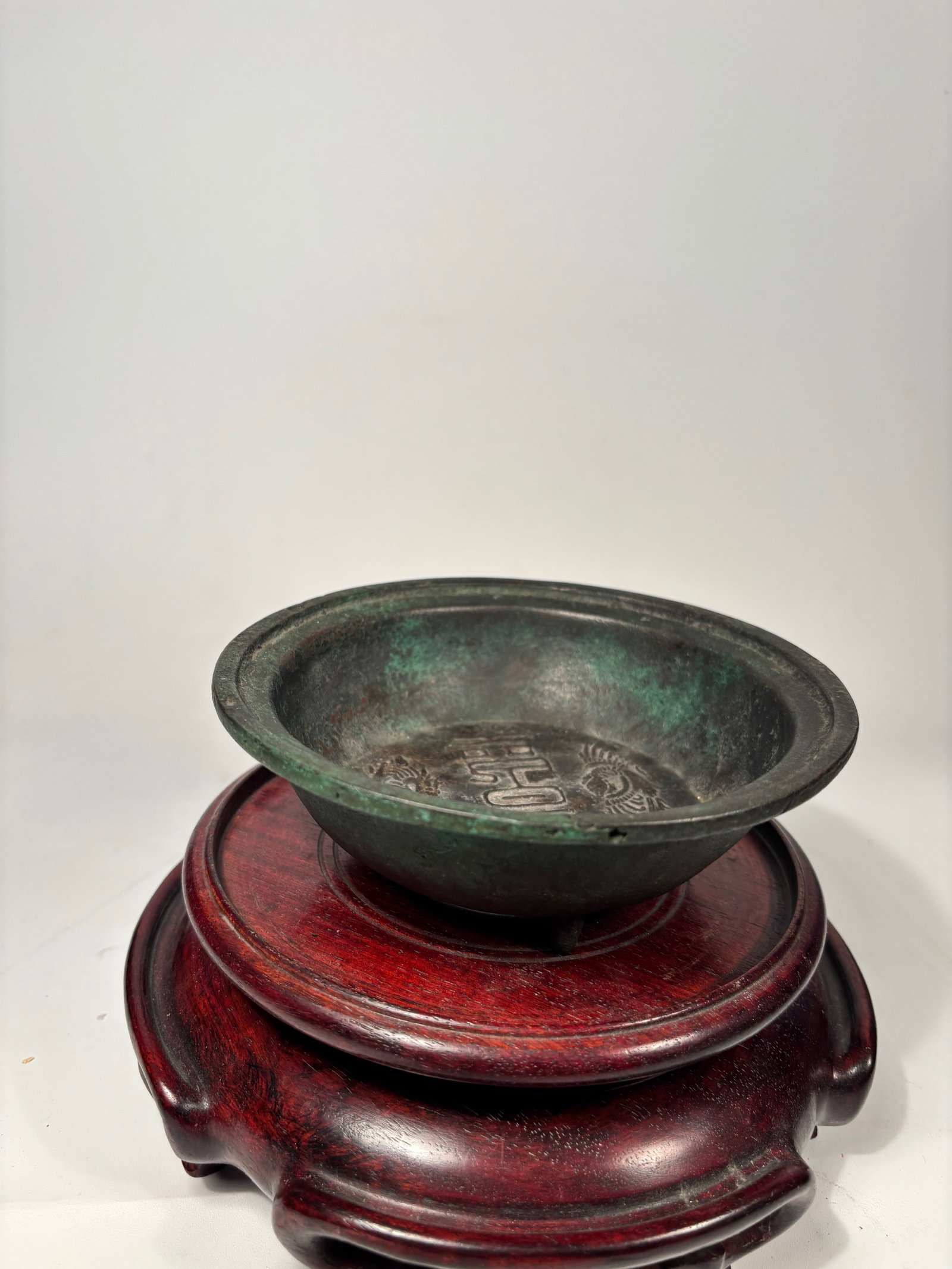 An inscribed bronze ‘dragon and phoenix’ washer, Yuan dynasty: Attributed to the Yuan dynasty (1279–1368), this piece was likely intended for scholar’s table use. A circular bronze washer cast with a central design of a dragon and a phoenix flanking a vertica
