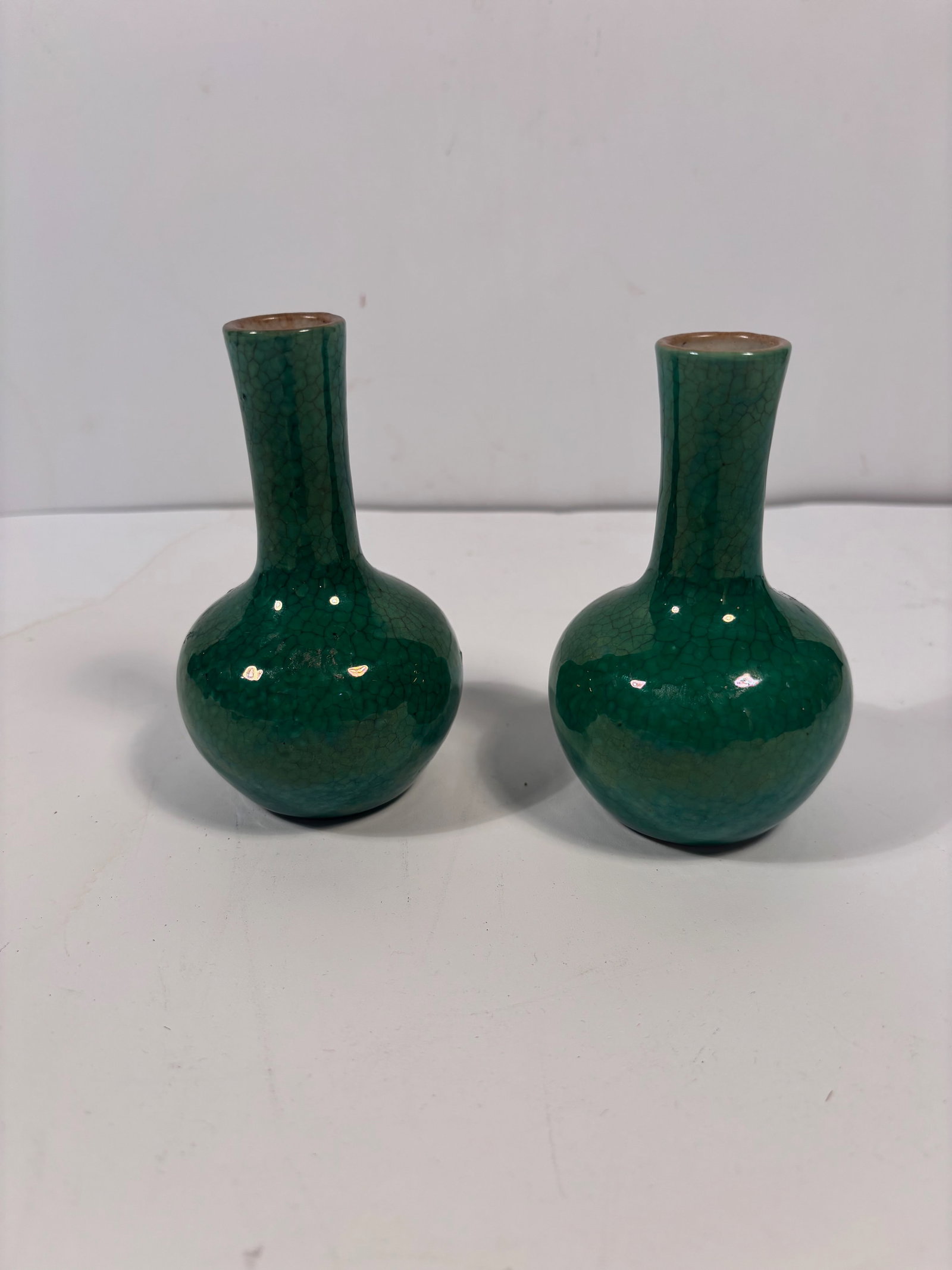 A pair of Chinese green galzed vases: Qing Dynasty (1644-1912). The surface features a pronounced crackle (or crazing) pattern, also it has the rich, emerald green glaze . Dimensions?Height: 4.5 inches.