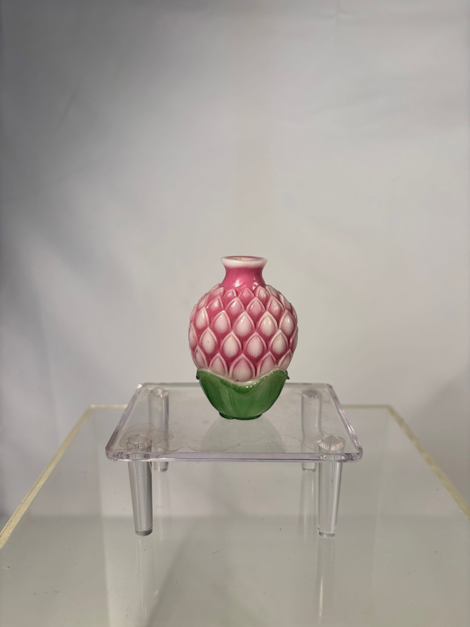 Chinese Peking Glass Overlay Snuff Bottle – Lotus Bud Form, Pink & Green Carving: Qing Dynasty(1644-1912); A beautifully carved Chinese Peking glass snuff bottle, fashioned in the form of a lotus bud or sacred fruit. The bottle features a striking pink and green overlay on an opaqu