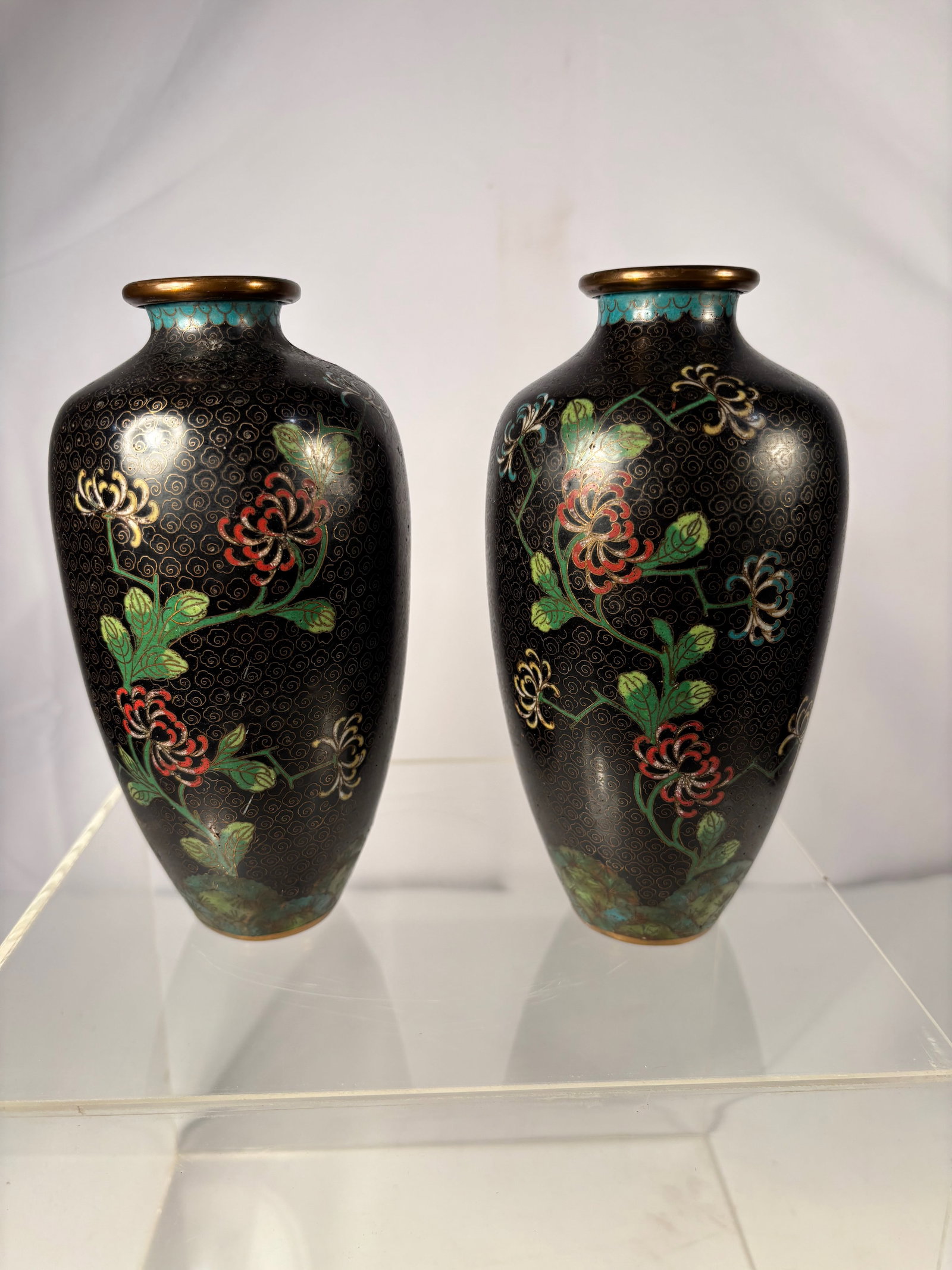 Pair of Chinese Cloisonné Enamel Vases with Chrysanthemum Design: Qing dynasty(1644-1912); A pair of elegant Chinese cloisonné enamel vases, each of ovoid form with gently waisted necks, finely decorated with blossoming chrysanthemum and leafy scrolls in polychrome