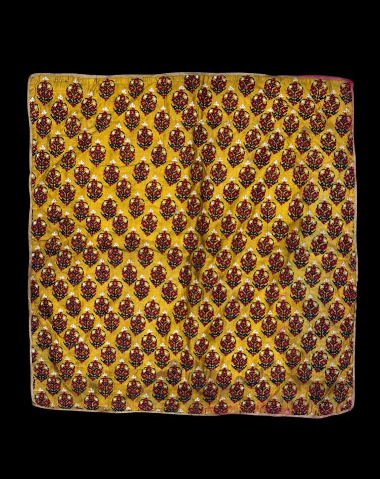 Antique Indian Hand-Embroidered Yellow Silk Textile Panel: An antique Indian textile panel crafted from golden-yellow silk and decorated with repeating stylized floral motifs. The hand-embroidered design features deep burgundy, black, white, and gold-toned th