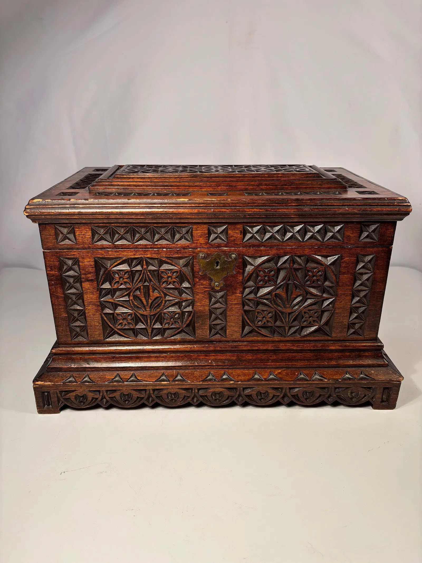 Late 19th Century European Hand-Carved Wooden Document Box with two Brass handles and Escutcheon: A large European hand-carved wooden document box, richly decorated with deep chip-carved geometric and floral motifs on the hinged lid and all sides. The craftsmanship shows excellent symmetry and fin
